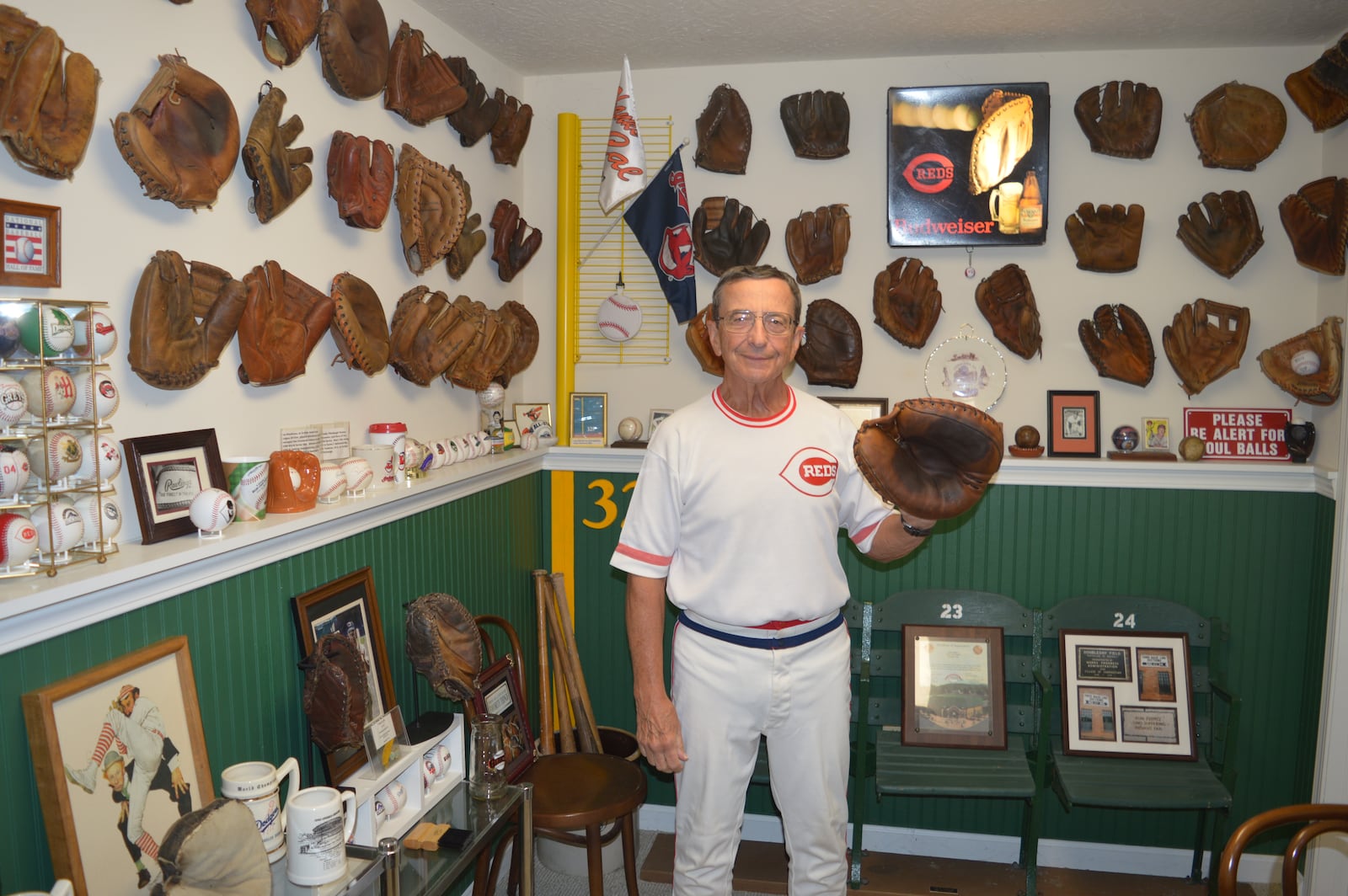 Ron Zemko poses wearing a catcher’s mitt in the “glove room” of his basement. His baseball glove collection has outgrown that room, however and some of his 245 gloves are displayed on the floor against the wall of other parts of the basement. CONTRIBUTED/BOB RATTERMAN