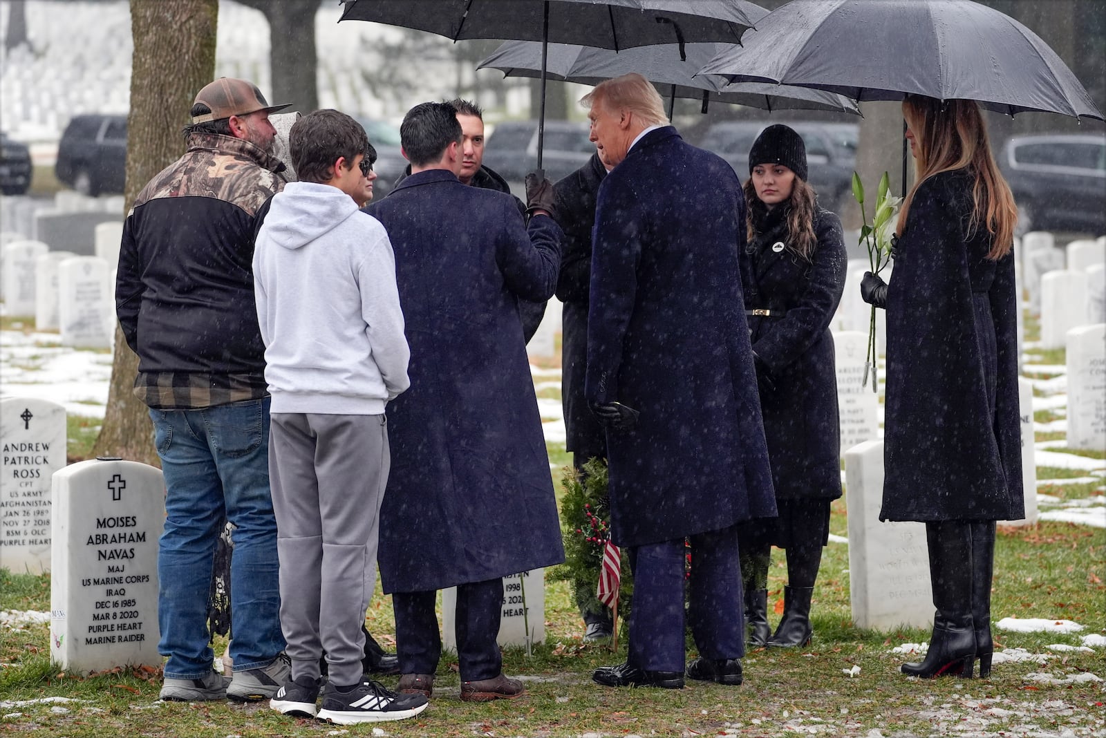 President-elect Donald Trump greets family members at the grave of Marine Corps Sgt. Nicole Gee in Section 60 at Arlington National Cemetery, Sunday, Jan. 19, 2025, in Arlington, Va. (AP Photo/Evan Vucci)