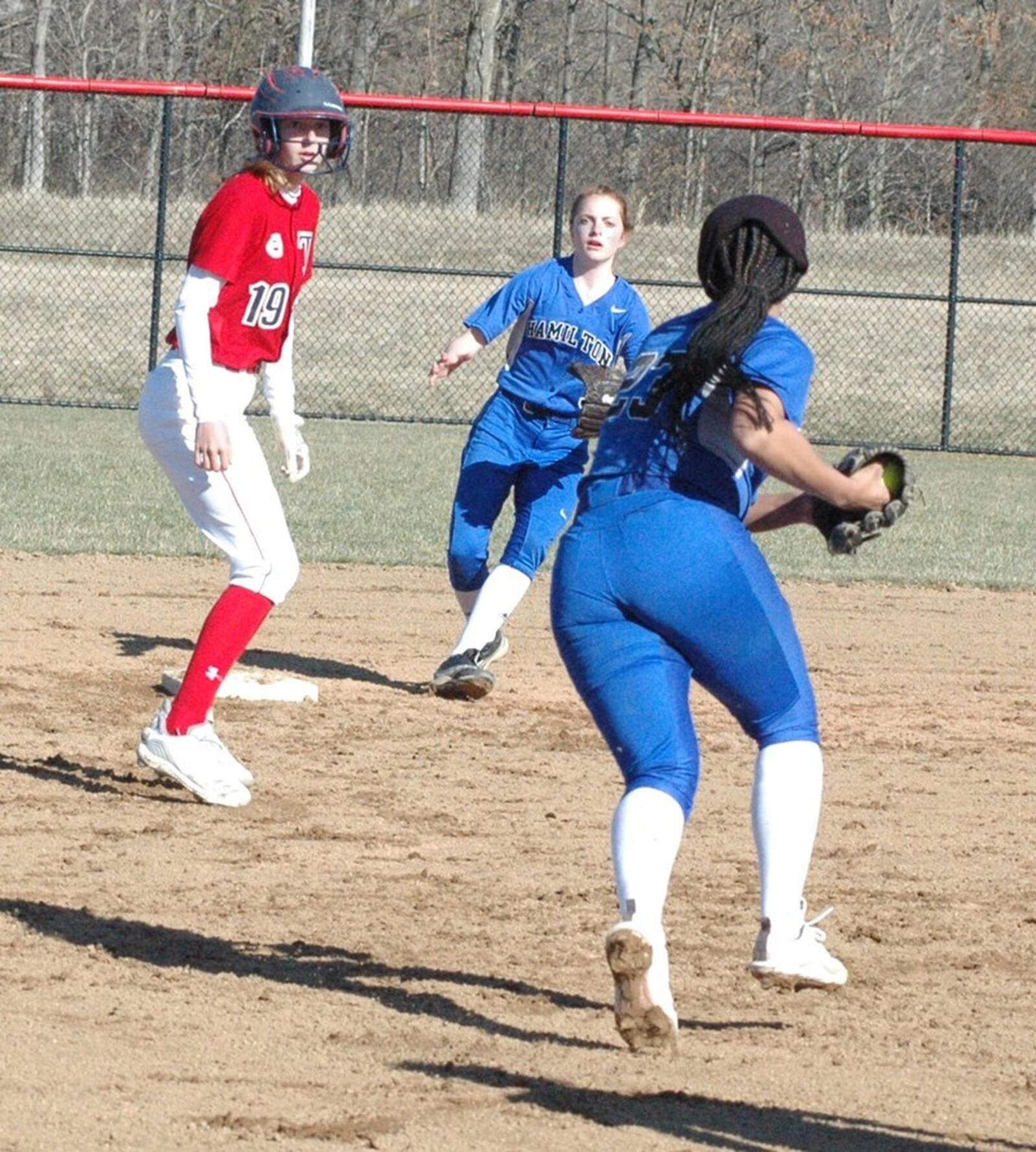 Talawanda’s Ashley Earick is between Hamilton’s Mya Halcomb (with ball) and Lilli Hilsercop on March 26 during a nonconference softball game in Oxford. Earick made it back to second base safely on the play. Talawanda won 4-1. RICK CASSANO/STAFF