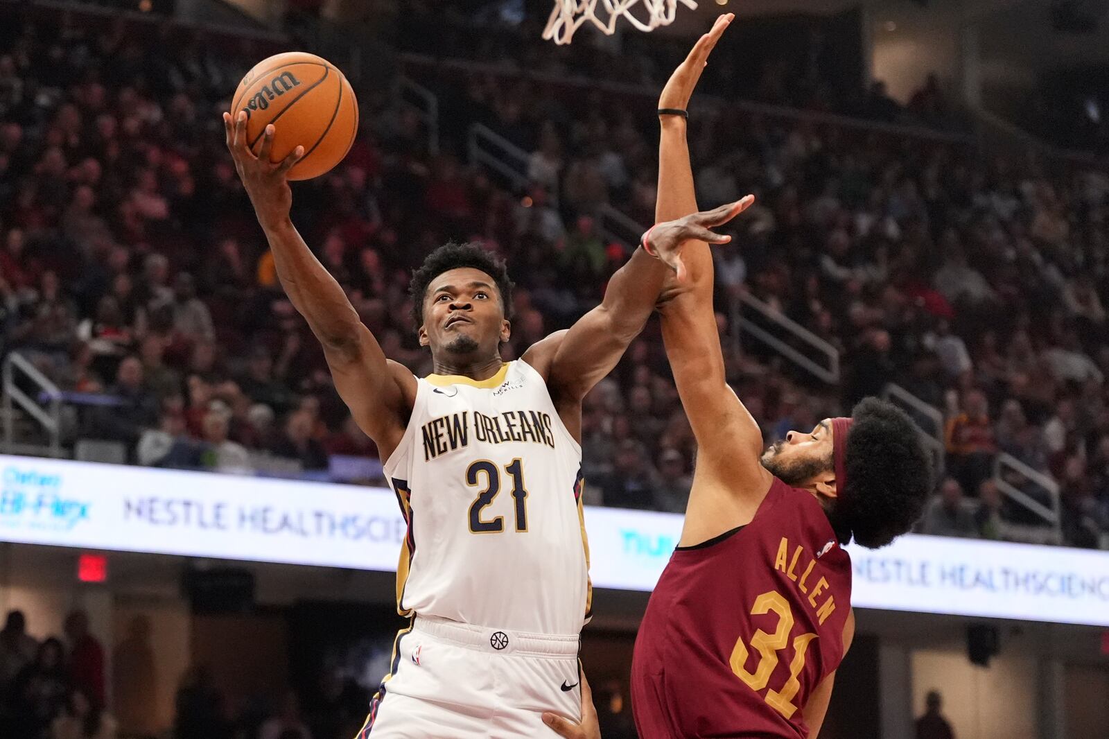 New Orleans Pelicans center Yves Missi (21) shoots as Cleveland Cavaliers center Jarrett Allen (31) defends in the first half of an NBA basketball game, Wednesday, Nov. 20, 2024, in Cleveland. (AP Photo/Sue Ogrocki)