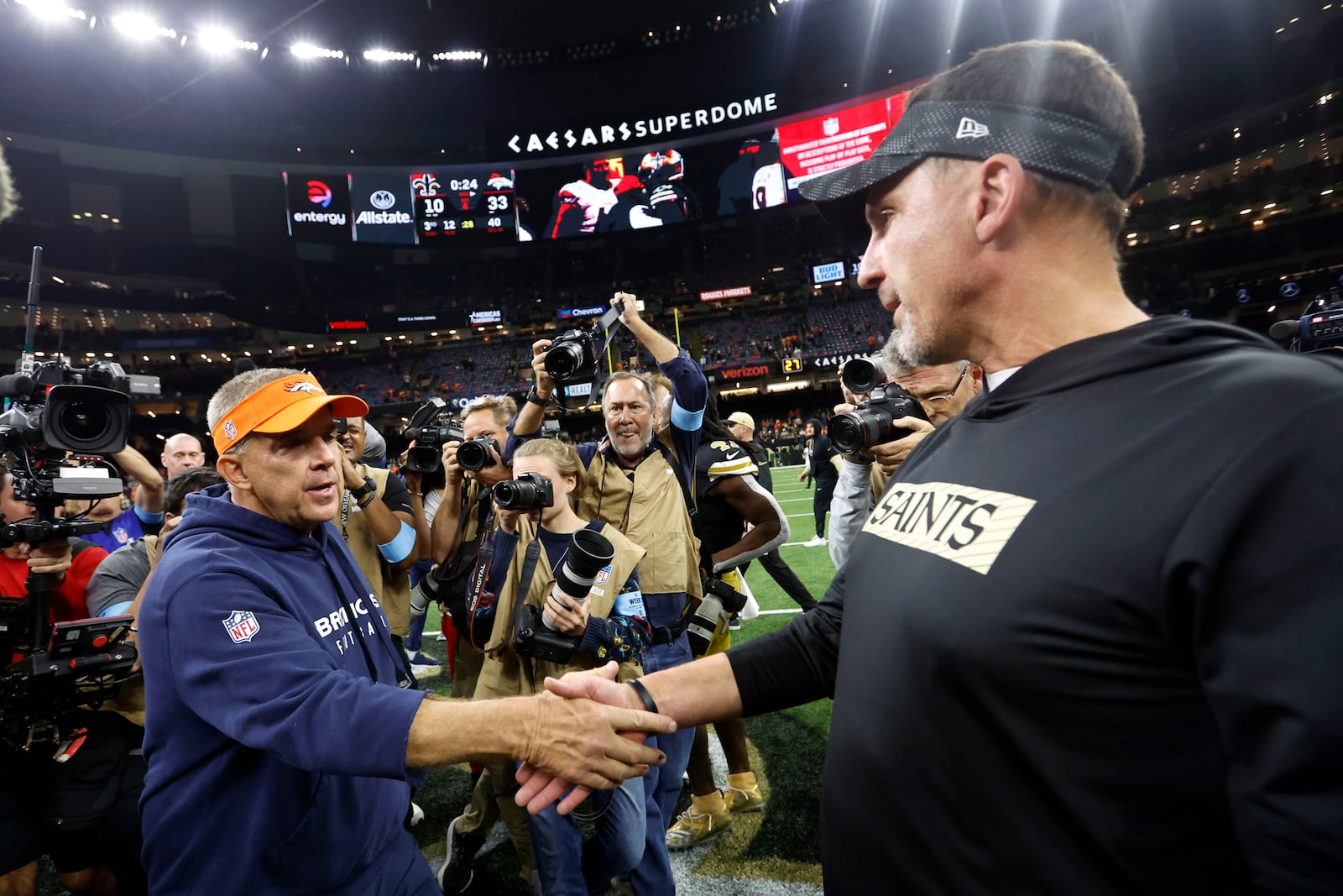 Denver Broncos head coach Sean Payton, left, greets New Orleans Saints head coach Dennis Allen after an NFL football game, Thursday, Oct. 17, 2024, in New Orleans. The Broncos won 33-10. (AP Photo/Butch Dill)