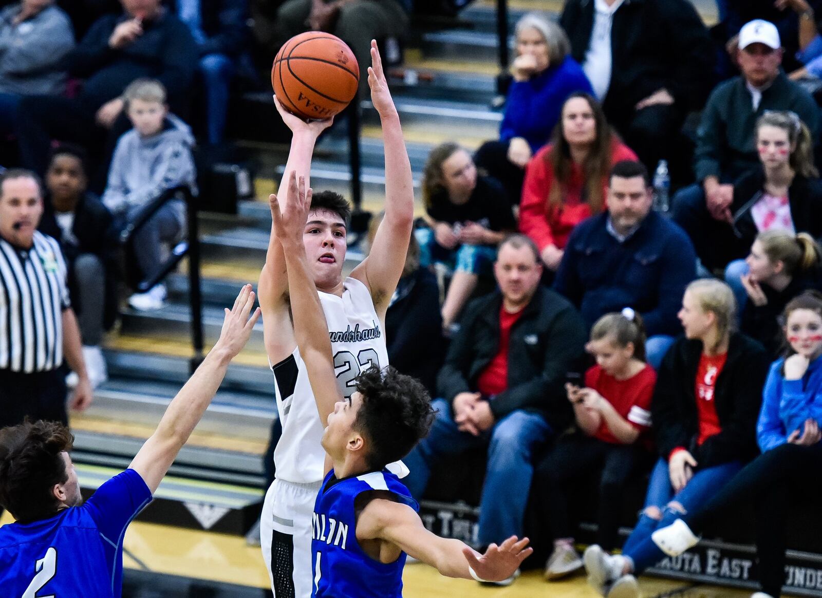 Lakota East’s Bash Wieland goes up for a shot defended by Hamilton’s Kurtis Reid (left) and Trey Robinson on Friday night in Liberty Township. Hamilton won 65-62. NICK GRAHAM/STAFF