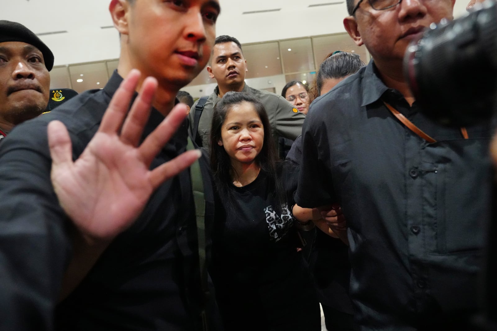 Mary Jane Veloso, center, a Filipina who was on death row in Indonesia and was nearly executed by firing squad in 2015, is escorted by Indonesian officials upon arrival at Soekarno-Hatta International Airport for her repatriation to the Philippines, in Tangerang, Indonesia, Tuesday, Dec. 17, 2024. (AP Photo/Tatan Syuflana)