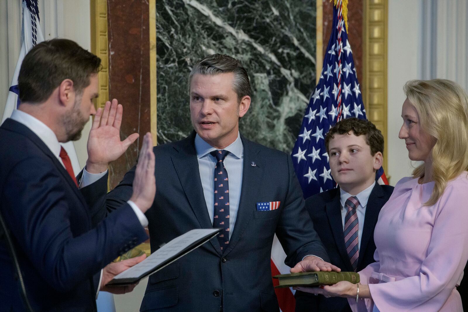 Vice President JD Vance, from left, swears in Pete Hegseth as Secretary of Defense as his wife Jennifer Rauchet, right, holds the Bible, as one of Hegseth's children watch in the Indian Treaty Room of the Eisenhower Executive Office Building on the White House campus in Washington, Saturday, Jan. 25, 2025. (AP Photo/Rod Lamkey, Jr.)