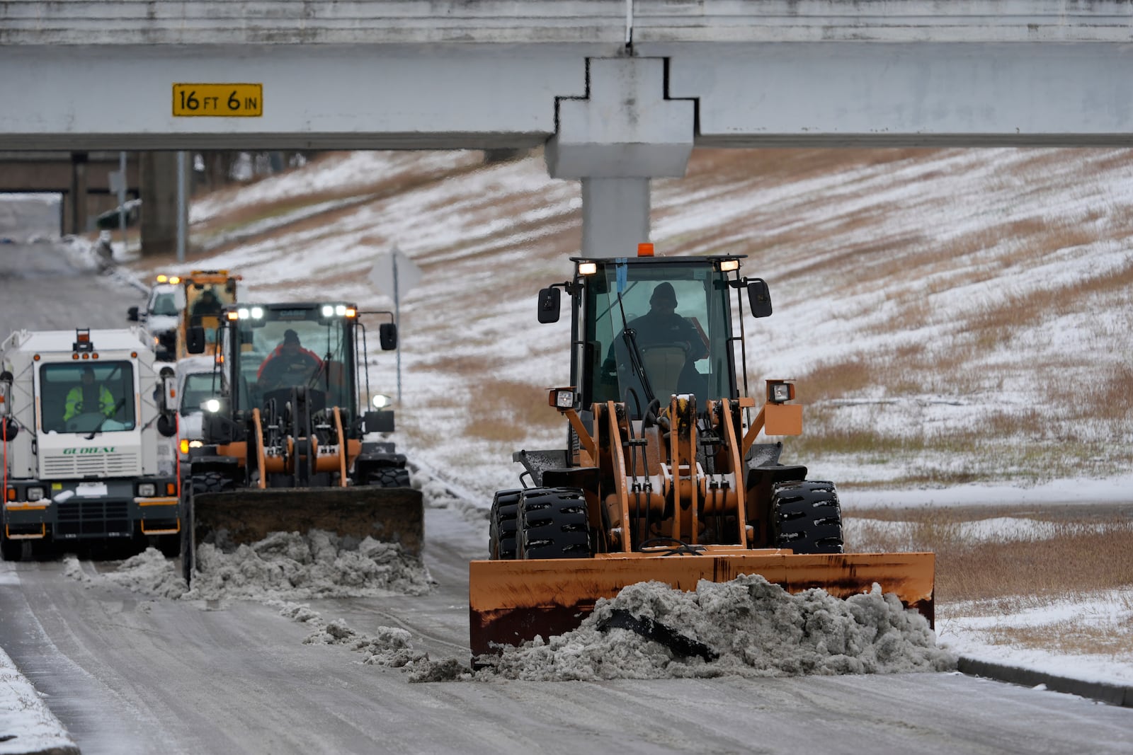 Workers plow snow off the roadways at the closed George Bush Intercontinental Airport Tuesday, Jan. 21, 2025, in Houston. (AP Photo/David J. Phillip)