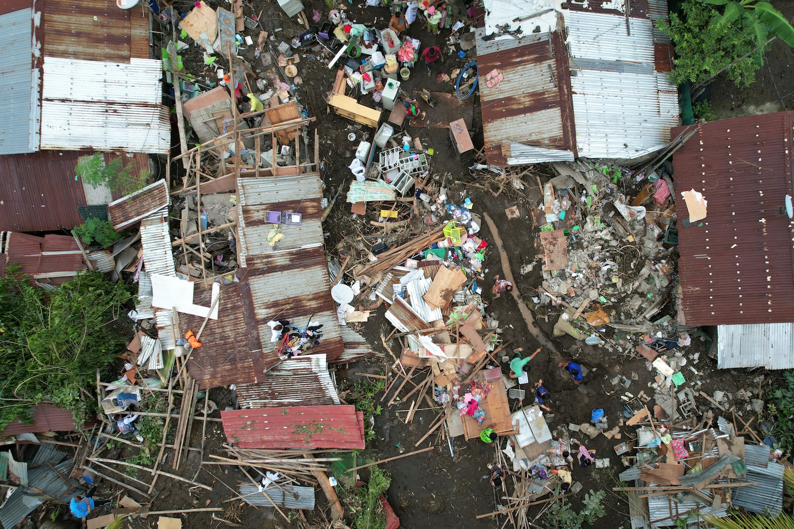 Residents gather what they can from their damaged homes on Saturday, Oct. 26, 2024 after being struck by a landslide triggered by Tropical Storm Trami in Talisay, Batangas province, Philippines. (AP Photo/Aaron Favila)