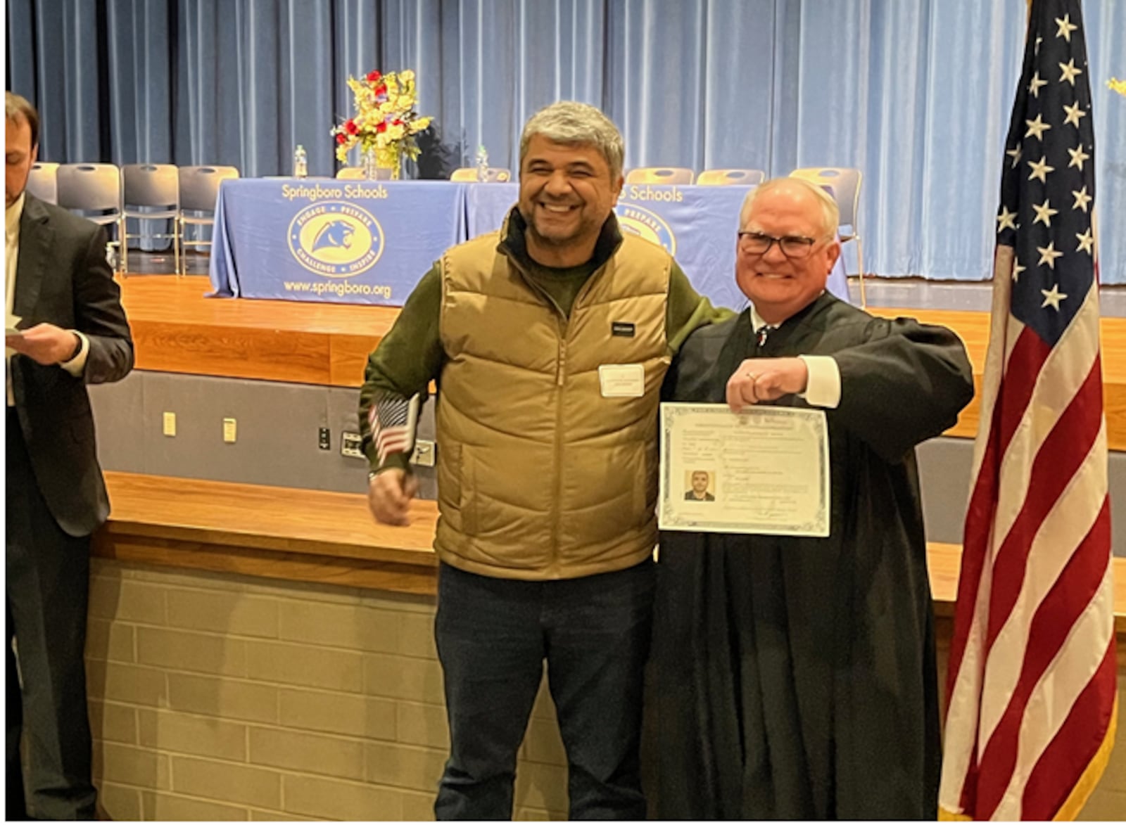 Mohammed Essa, left, formerly of Palestine, poses with U.S. Bankruptcy Judge Guy R. Humphrey with his naturalization certificate following the Naturalization Ceremony held Thursday, March 21, 2024 at Springboro High School. ED RICHTER/STAFF