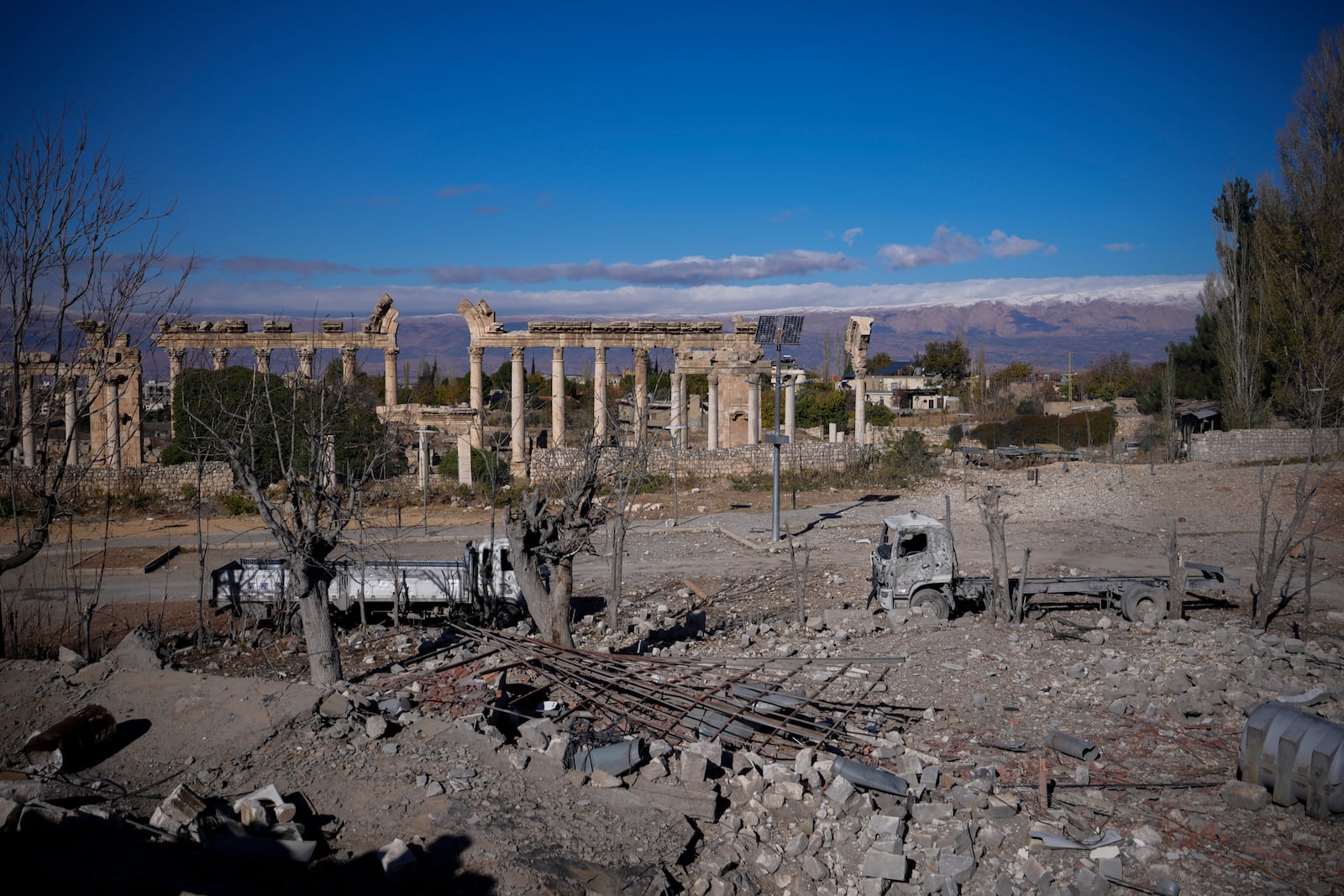 Damaged vehicles seen in front of the Roman temples of Baalbek in eastern Lebanon, Thursday, Nov. 28, 2024. (AP Photo/Hassan Ammar)