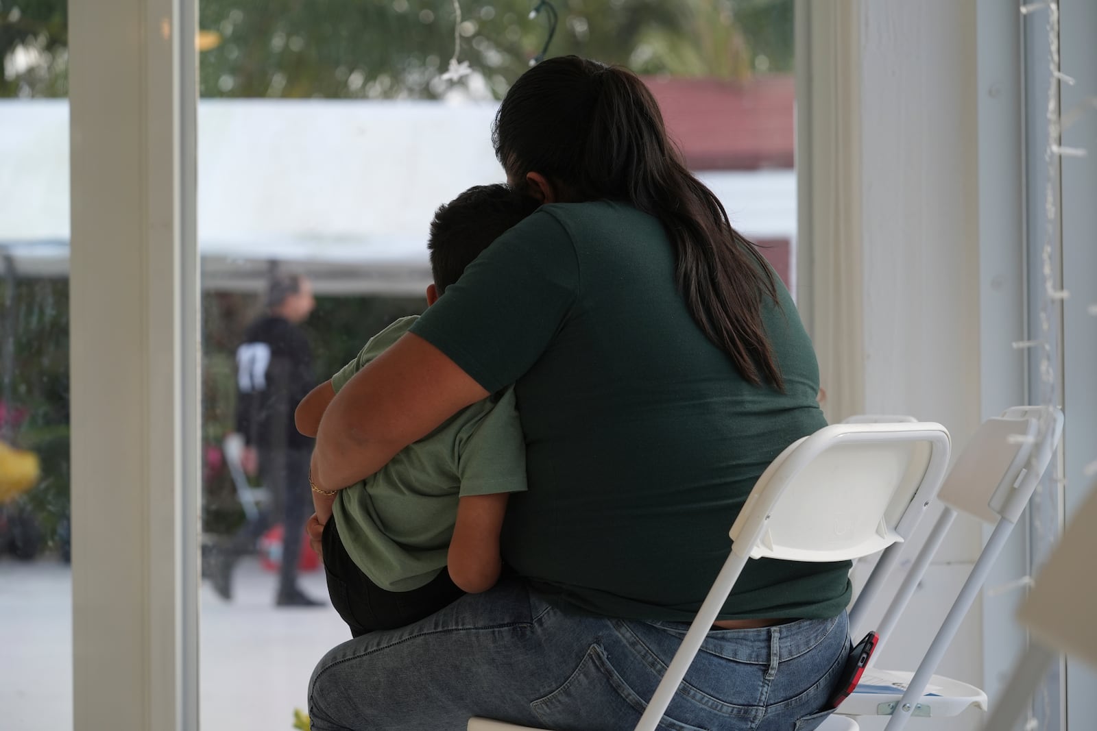 A mother embraces her son after signing a document giving Nora Sandigo legal guardianship of her minor children if she is detained or deported by immigration authorities, Sunday, Jan. 19, 2025, in Miami. Sandigo runs a non-profit organization that helps immigrants and their families. (AP Photo/Marta Lavandier)