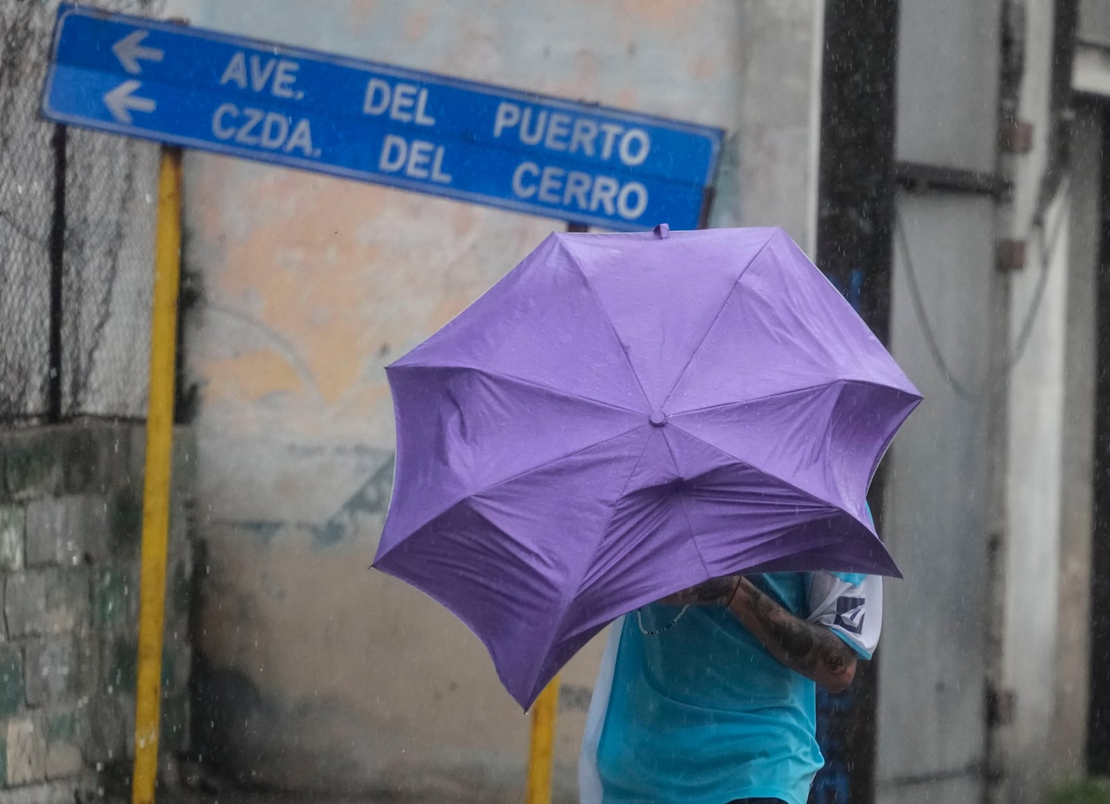 A man walks through the wind and rain brought by Hurricane Rafael in Havana, Cuba, Wednesday, Nov. 6, 2024. (AP Photo/Ramon Espinosa)