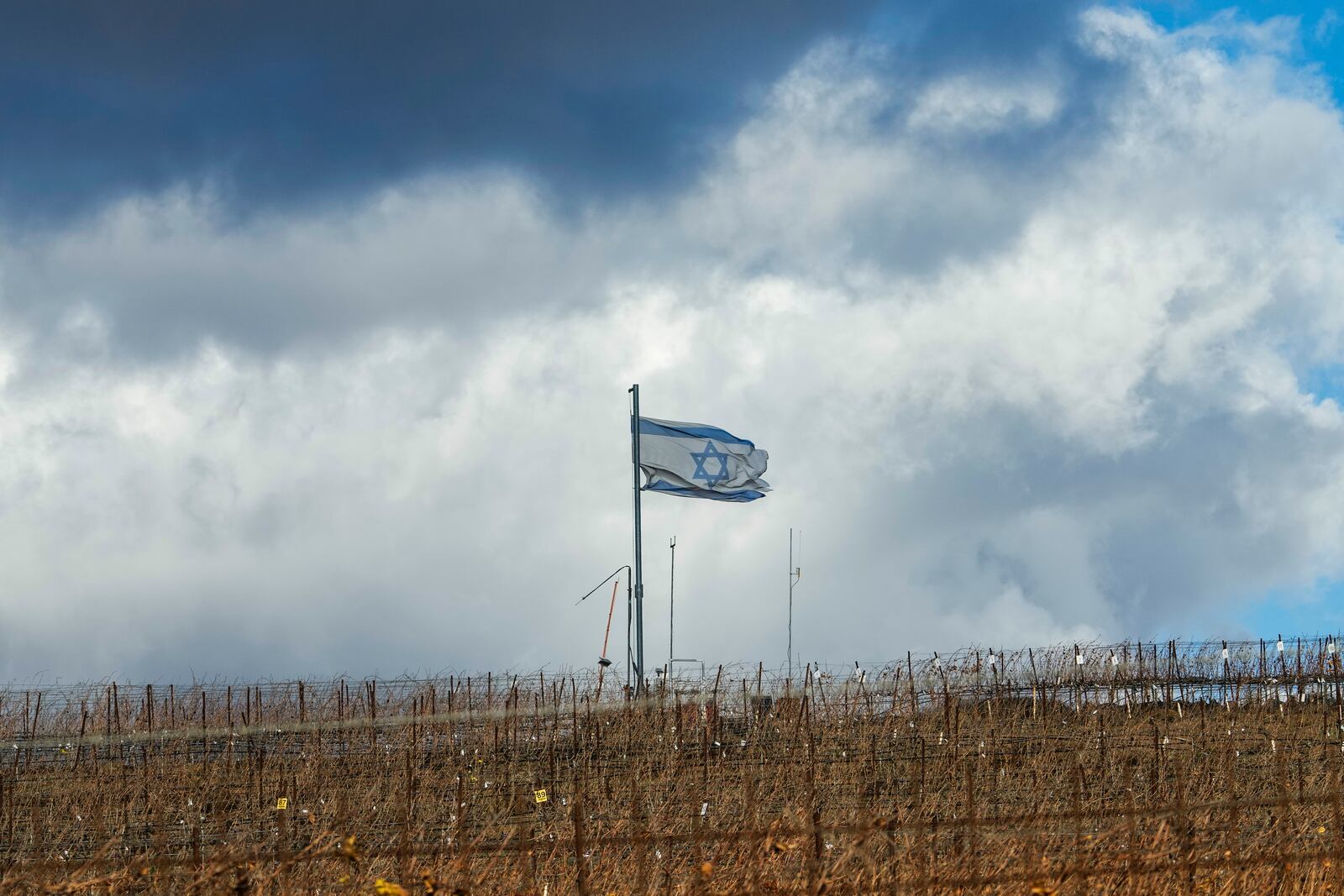 An Israeli flag waves on the top of a hill near the so-called Alpha Line that separates the Israeli-controlled Golan Heights from Syria, in the town of Majdal Shams, Friday, Dec. 13, 2024. (AP Photo/Matias Delacroix)