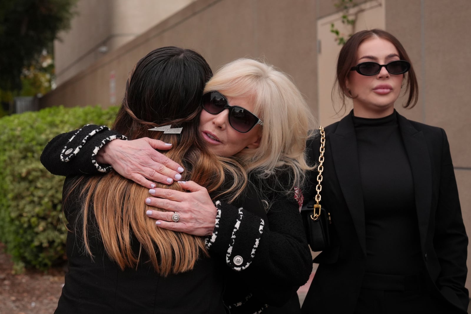 Tammi Menendez, center, the wife of Eric Menendez, is hugged by an unidentified woman as she leaves a courthouse after a hearing in Los Angeles, Monday, Nov. 25, 2024. (AP Photo/Jae C. Hong)