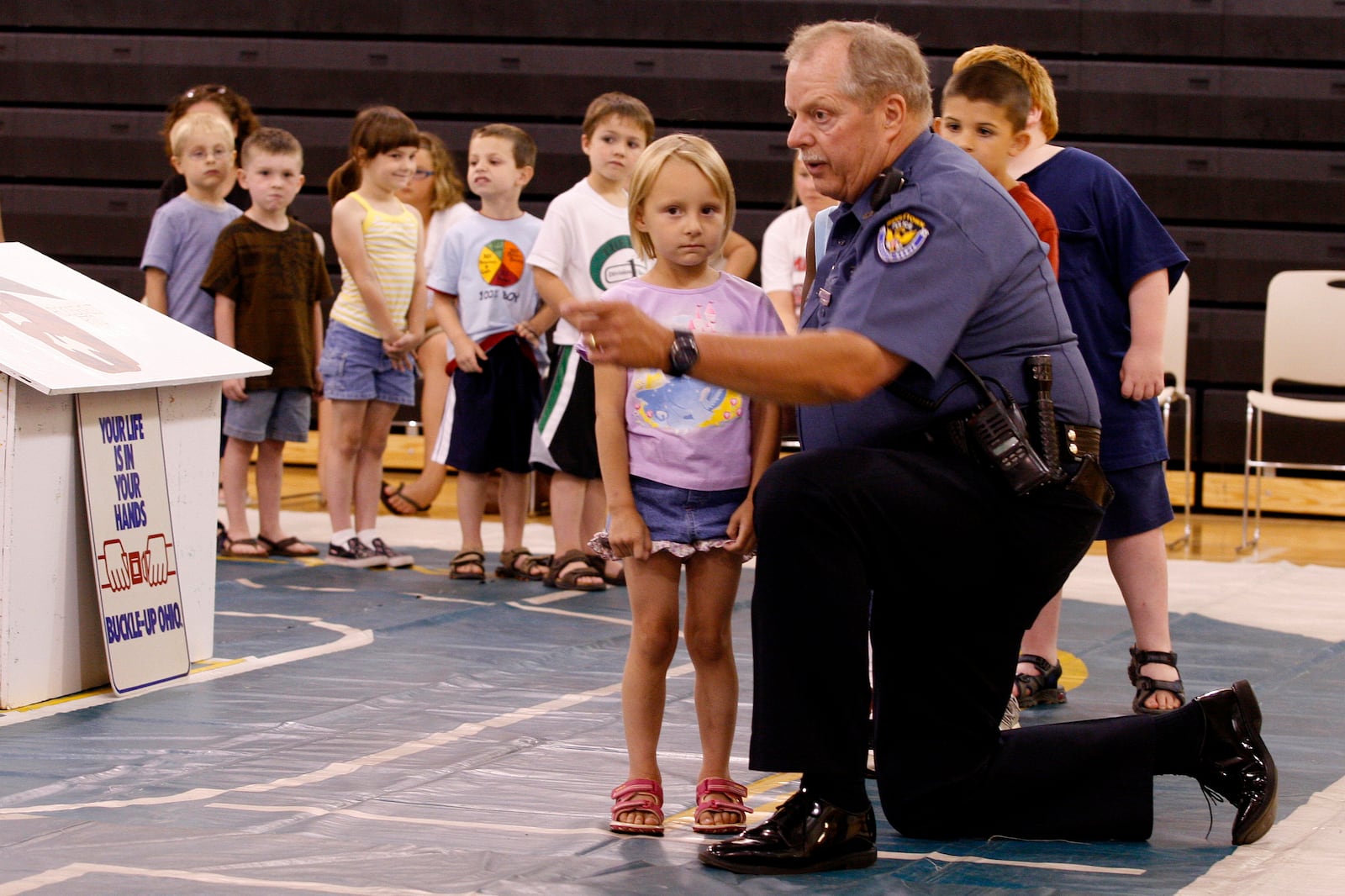 Middletown school resource officer Mike Davis tells Emmalee Dalton, 4, what car to get into during the first day of Patrolman Jack Combs Memorial Safety Town in 2008 at Amanda Elementary School in Middletown. Staff photo by Nick Graham