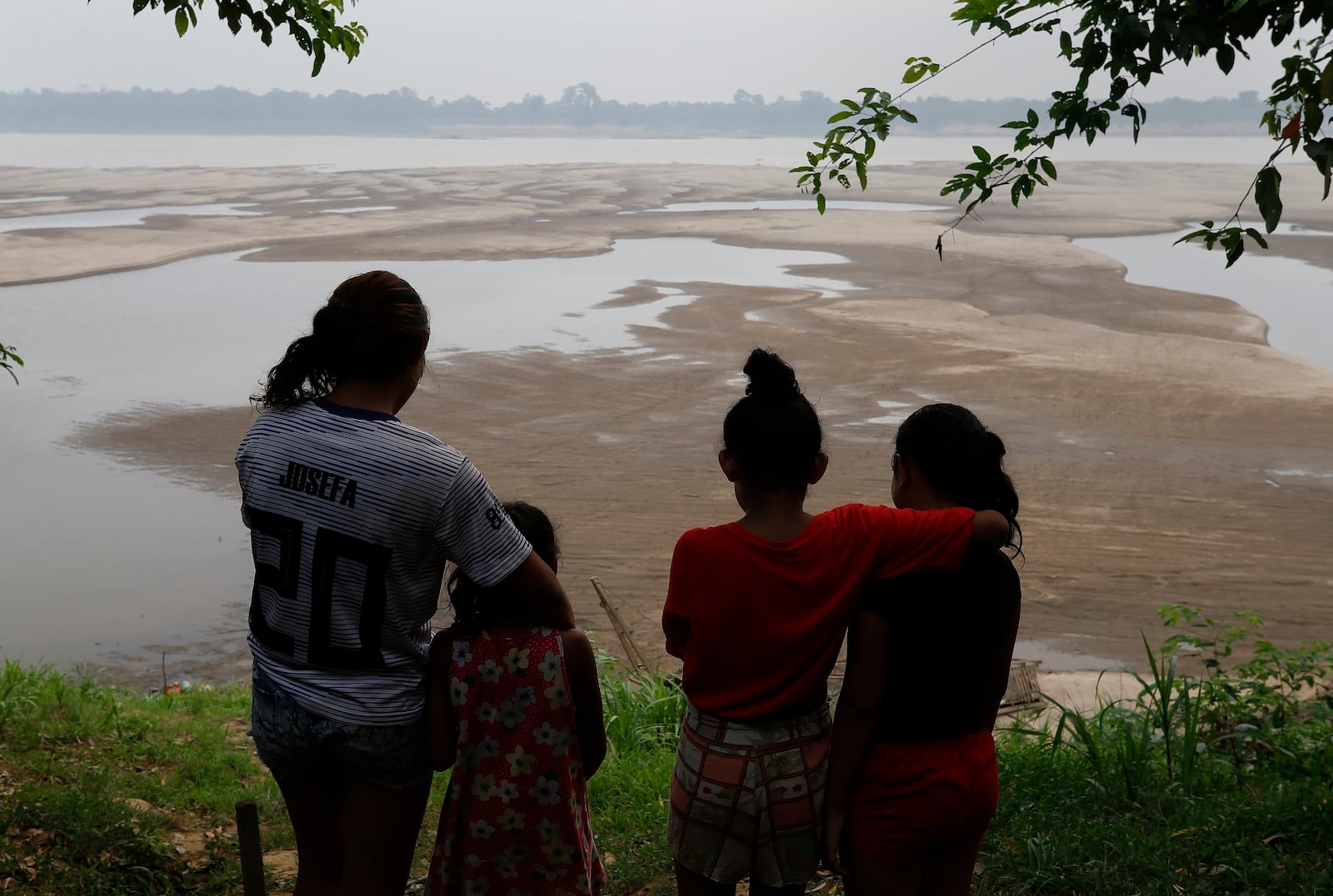 FILE - Residents look out at the Madeira River, a tributary of the Amazon River amid a drought in Humaita, Amazonas state, Brazil, Sept. 7, 2024. (AP Photo/Edmar Barros, File)