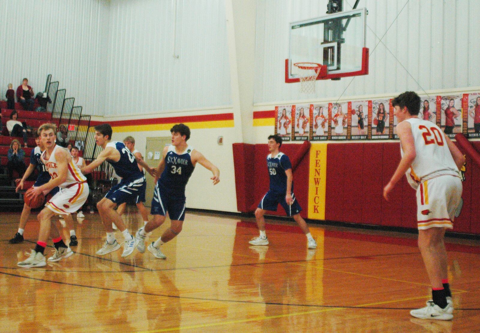 Fenwick's C.J. Napier prepares to send a pass to teammate A.J. Braun (20) during Saturday night's game against St. Xavier at Fenwick. That's Hank Thomas (20) and Thomas Kiessling (34) defending for the Bombers, who lost 58-53. RICK CASSANO/STAFF