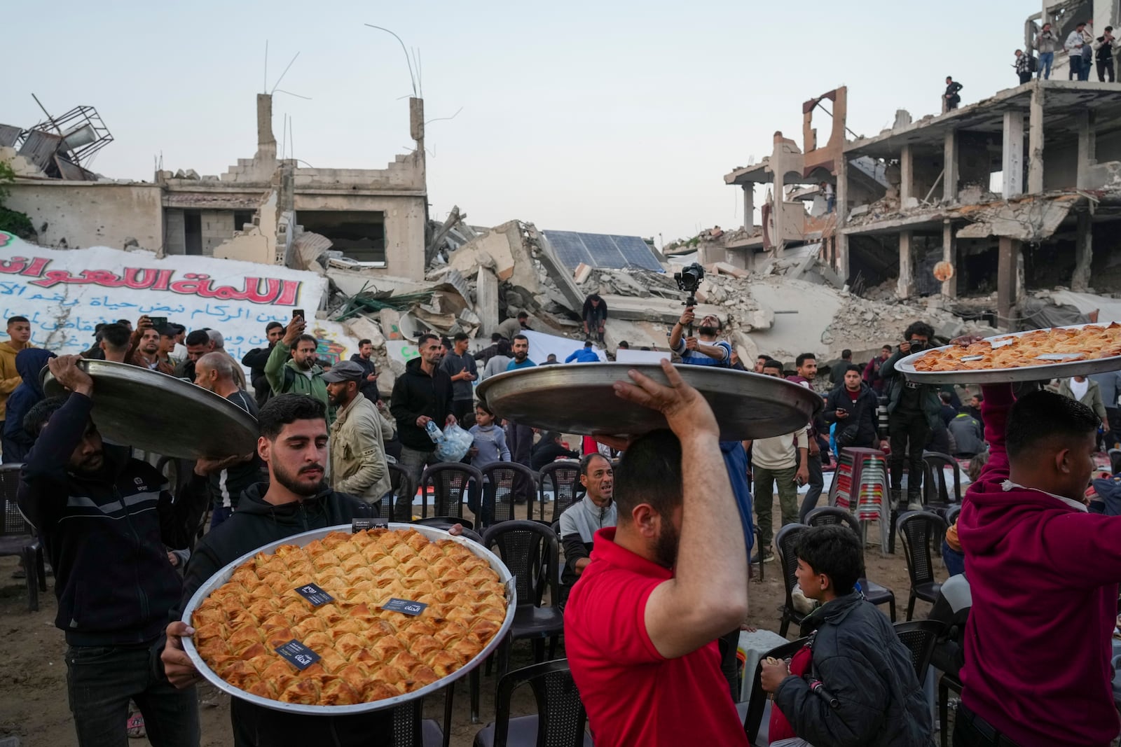 Traditional sweets are served at the tables as residents prepare for Iftar, the fast-breaking meal, during Ramadan in the war-devastated Beit Lahia, northern Gaza Strip, Saturday, March 15, 2025. (AP Photo/Jehad Alshrafi)