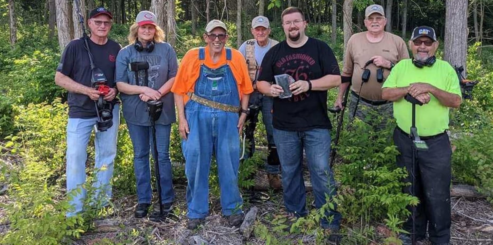 Jared Shank, center, holding a cell phone, is shown with other members of the Dayton Diggers last summer after the skilled group of metal detectors found a cell phone, a key piece of evidence related to a Lebanon homicide investigation. SUBMITTED