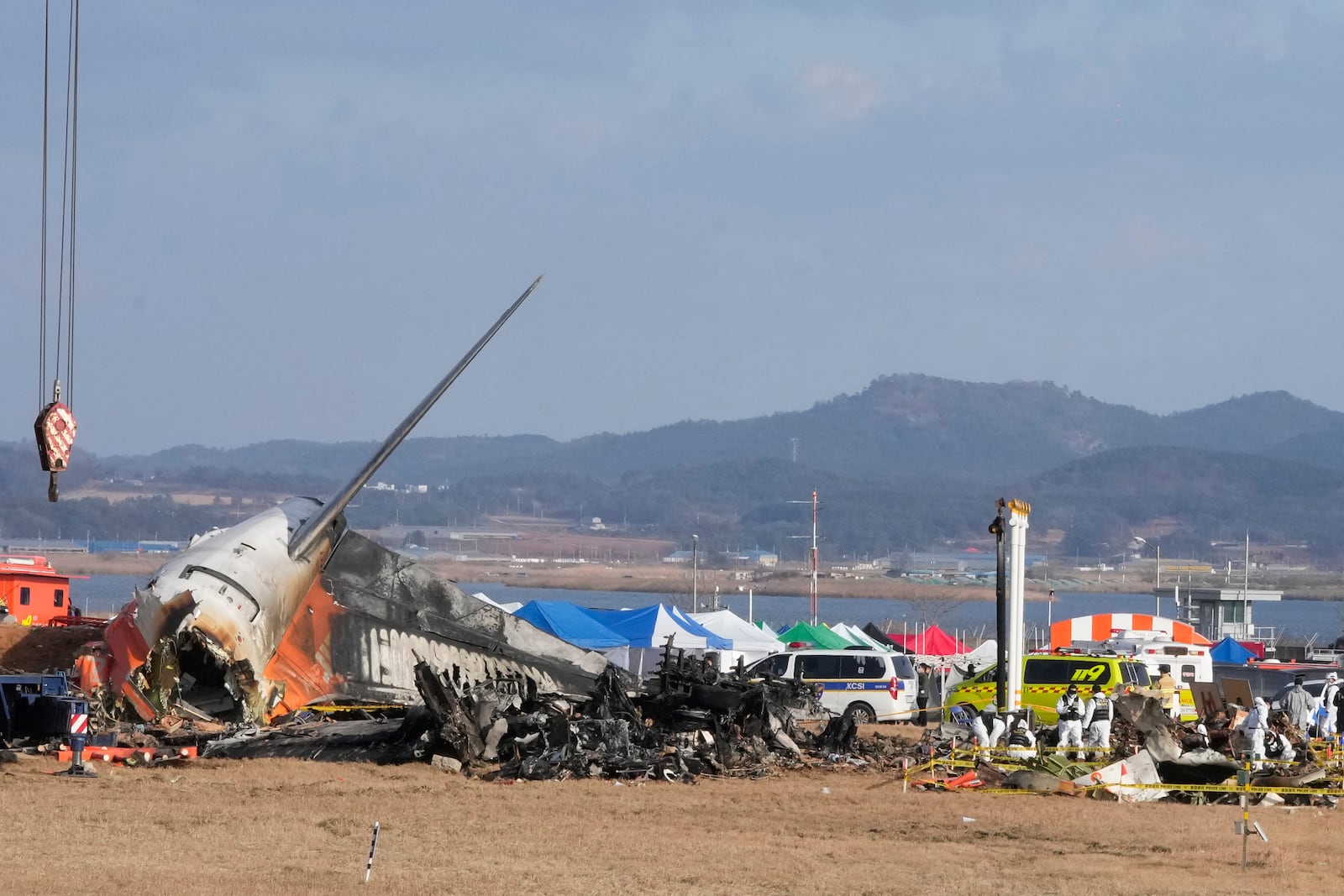 Rescue team members work at the site of a plane fire at Muan International Airport in Muan, South Korea, Monday, Dec. 30, 2024. (AP Photo/Ahn Young-joon)