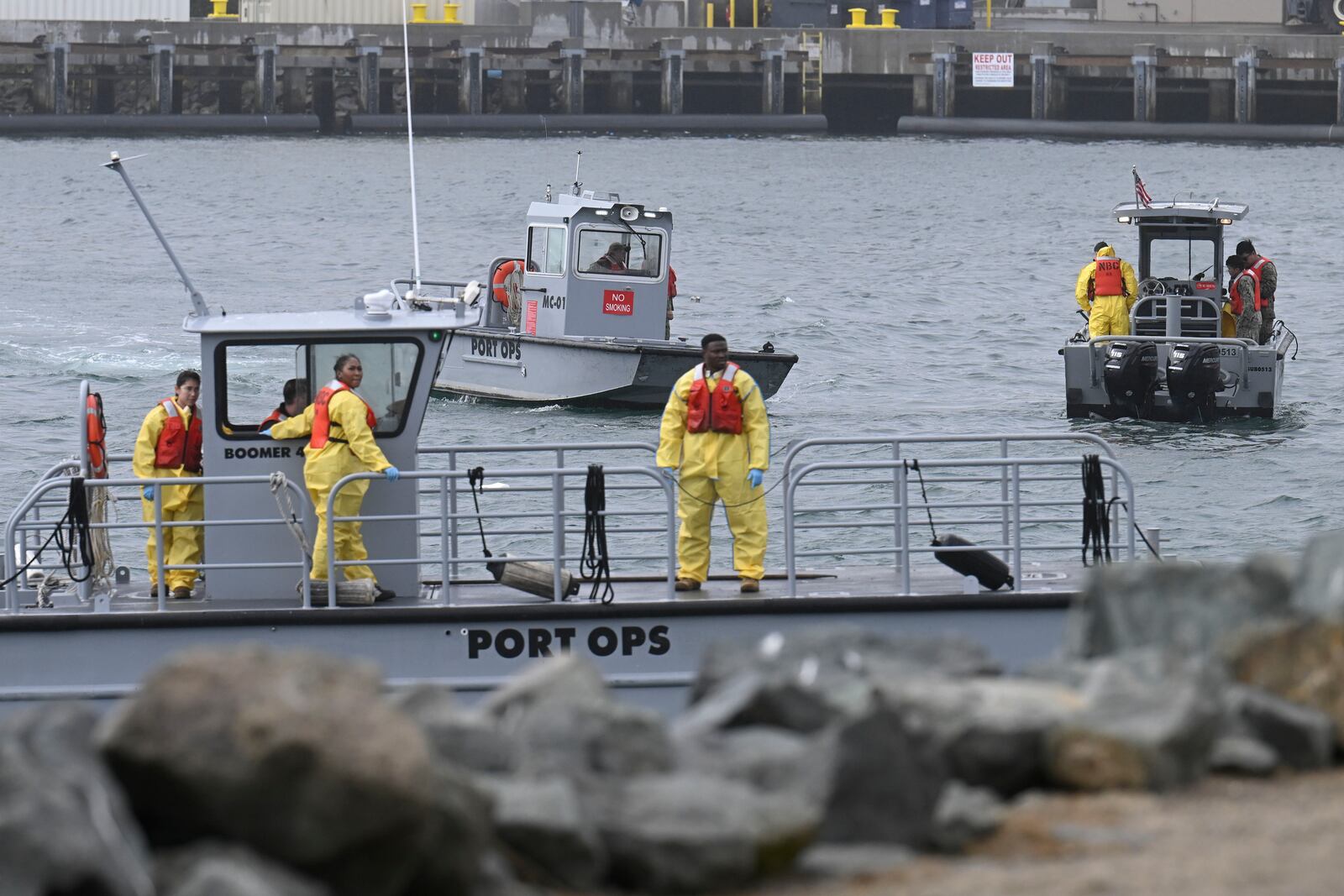 U.S. Navy boats work along the shore near Shelter Island after a U.S. Navy plane crashed into the San Diego Bay, Wednesday, Feb. 12, 2025, in San Diego. (AP Photo/Denis Poroy)