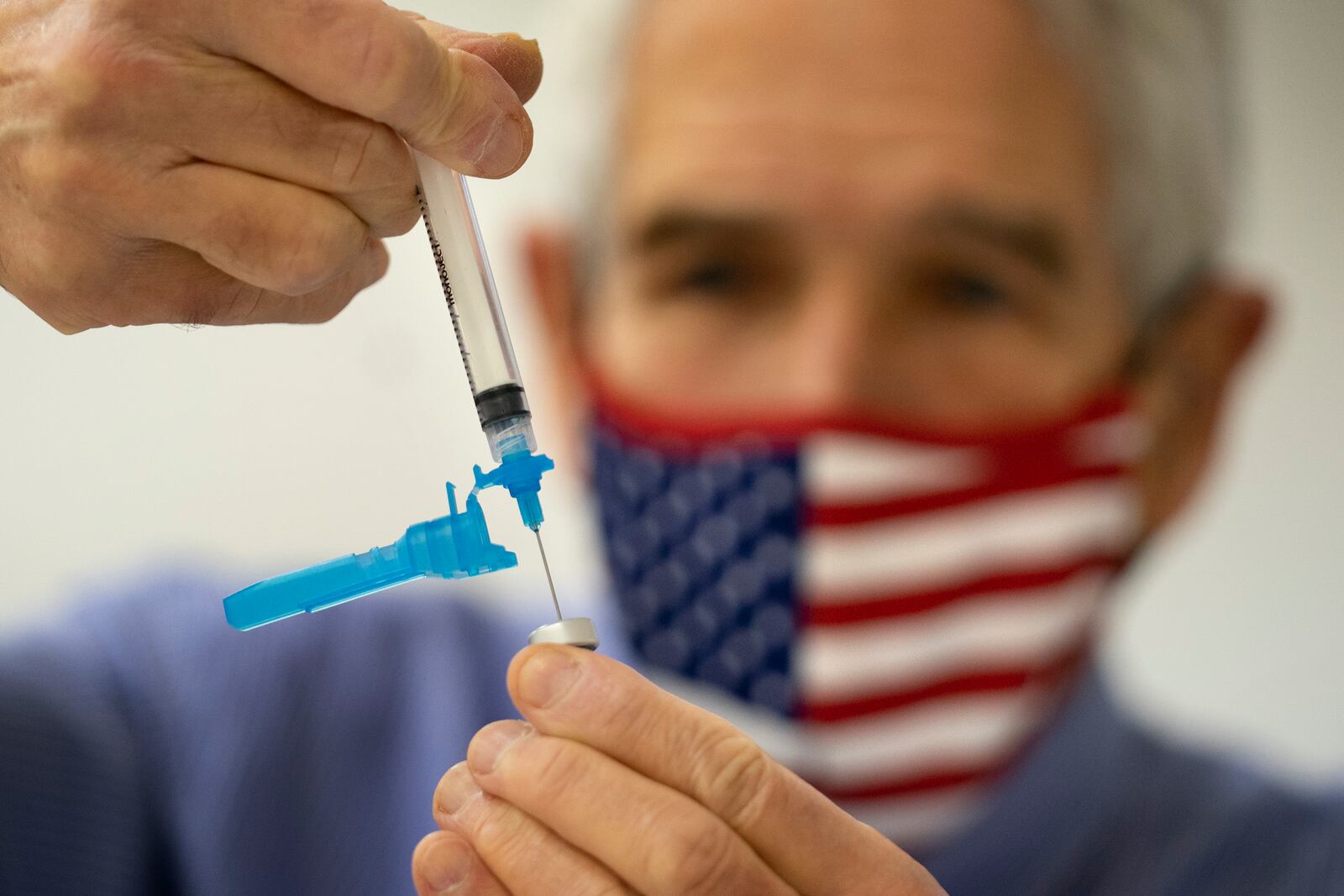 FILE - Dr. Sydney Sewall fills a syringe with the COVID-19 vaccine at the Augusta Armory, Dec. 21, 2021, in Augusta, Maine. (AP Photo/Robert F. Bukaty, File)