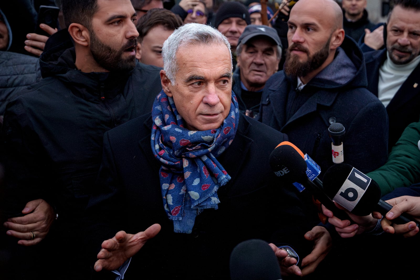 Calin Georgescu, an independent candidate for president who won the first round of presidential elections, speaks to media outside a voting station demanding to be allowed to vote after Romania's Constitutional Court annulled the first round of presidential elections, in Mogosoaia, Romania, Sunday, Dec. 8, 2024. (AP Photo/Andreea Alexandru)