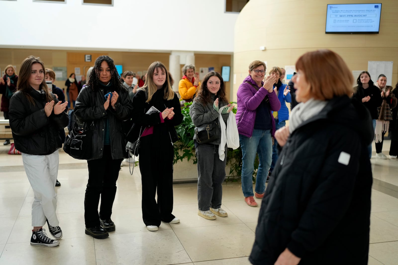 FILE - People applaud Gisèle Pelicot, front right, who was allegedly drugged by her then-husband so that he and others could sexually assault her, leaves the courthouse in Avignon, southern France, on Dec. 9, 2024. (AP Photo/Lewis Joly, File)