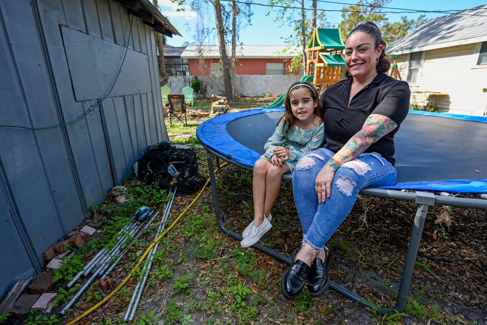 Cecila Grove and her daughter Aria Grove sit outside their home Saturday, Nov. 16, 2024, in Sarasota, Fla. (AP Photo/Steve Nesius)