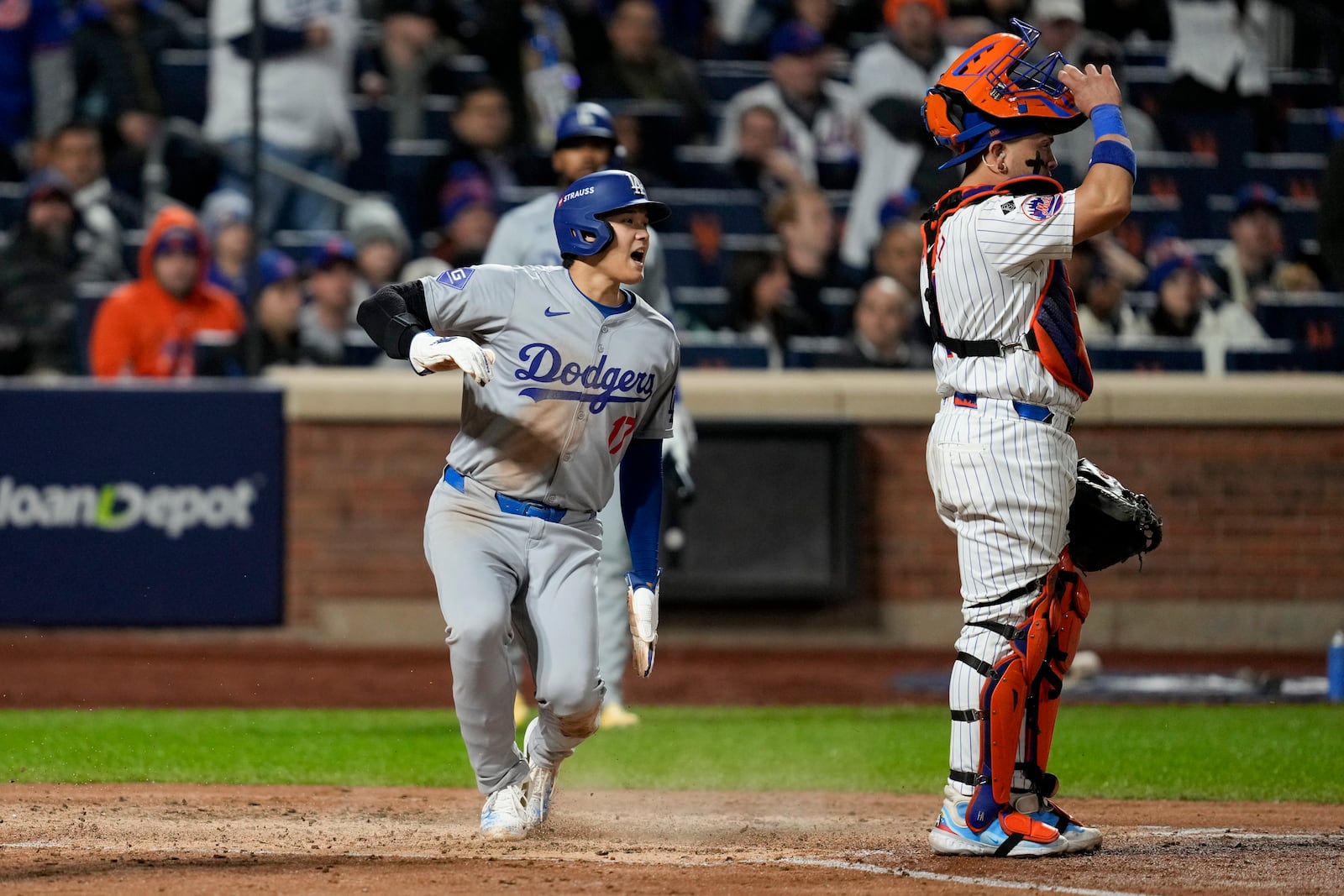 Los Angeles Dodgers' Shohei Ohtani scores past New York Mets catcher Francisco Alvarez on a double by Mookie Betts during the fourth inning in Game 4 of a baseball NL Championship Series, Thursday, Oct. 17, 2024, in New York. (AP Photo/Ashley Landis)