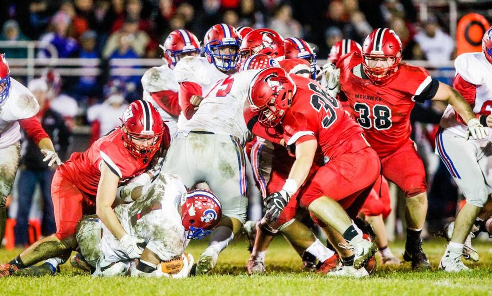 Portsmouth’s Talyn Parker (1) gets taken to the ground by Madison’s Tanner Limon (37) as teammates Cole Pelgen (36) and Max Evans (38) come forward during last Saturday night’s 26-0 victory in a Division V, Region 20 playoff game at Brandenburg Field in Madison Township. NICK GRAHAM/STAFF