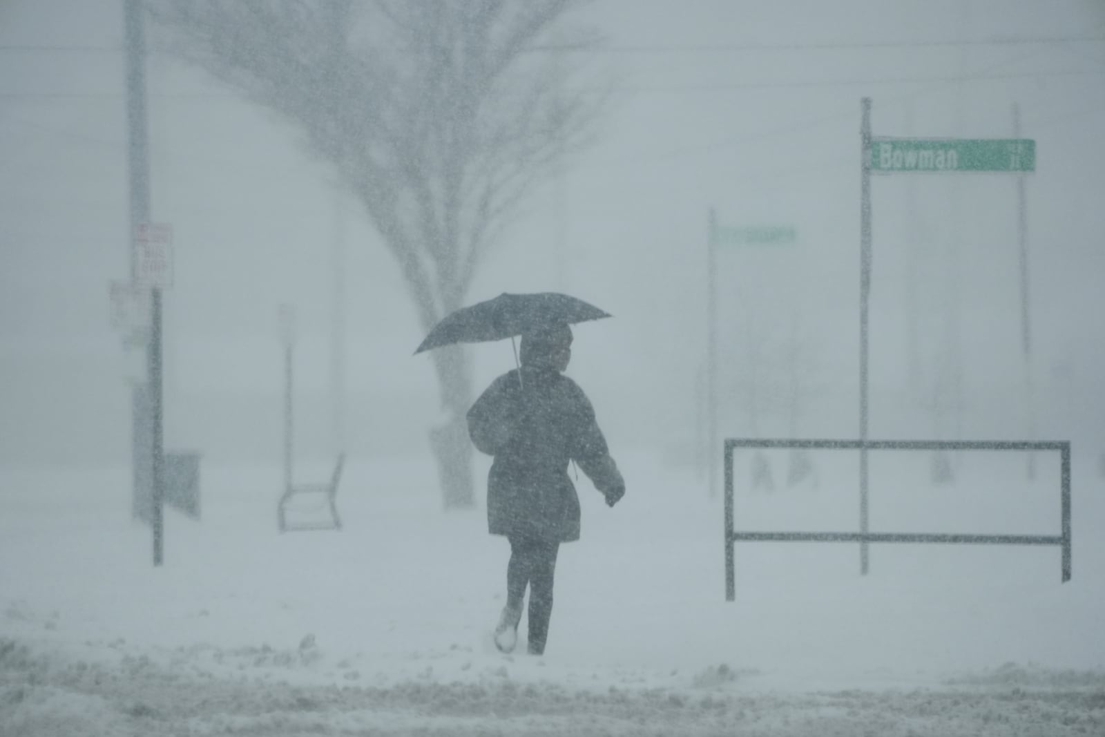 A person holds an umbrella as they walk during a winter storm, Monday, Jan. 6, 2025, in Cincinnati. (AP Photo/Joshua A. Bickel)