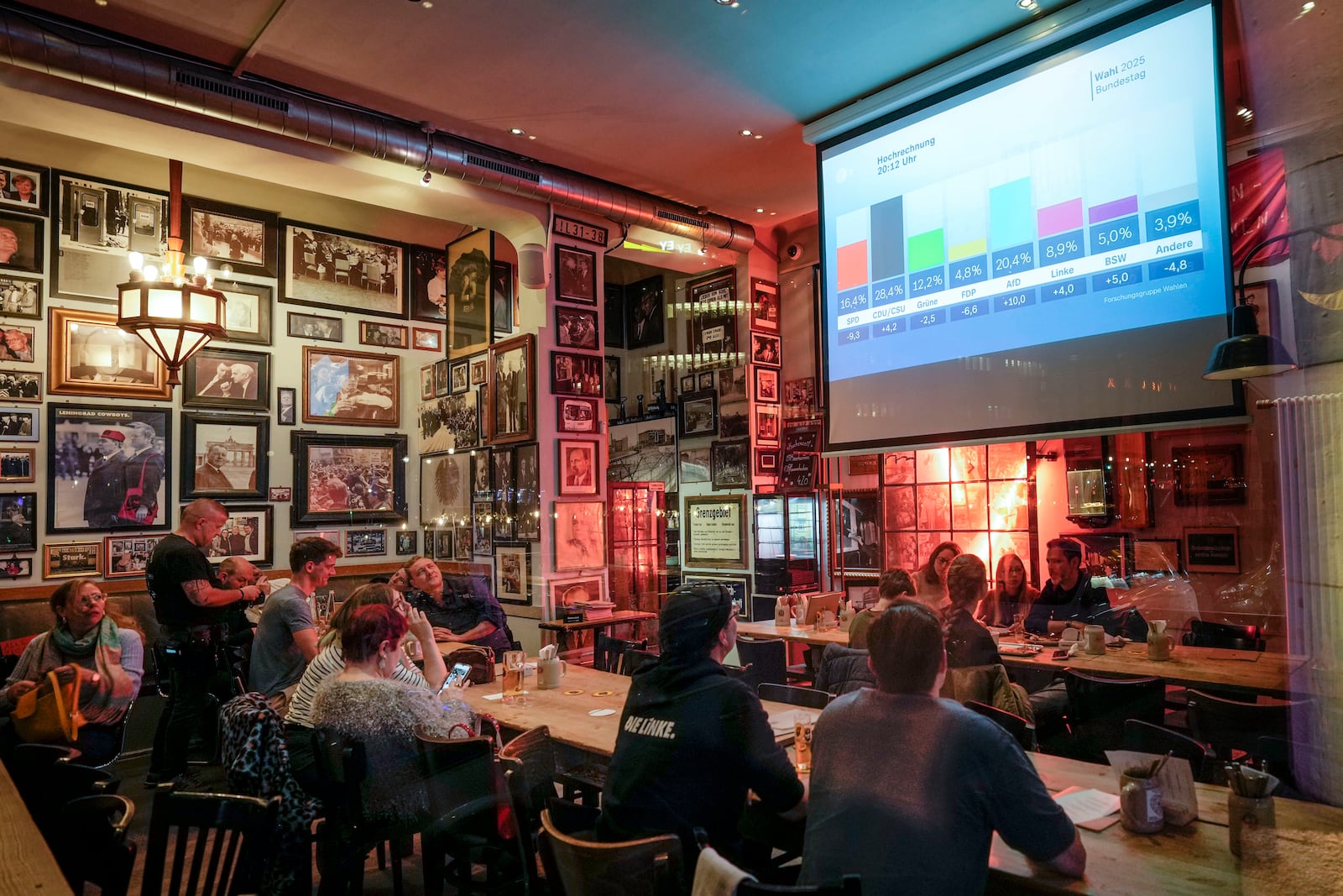 People watch first prjections at a pub in Berlin, Germany, Sunday, Feb. 23, 2025, after the German national election. (AP Photo/Martin Meissner)