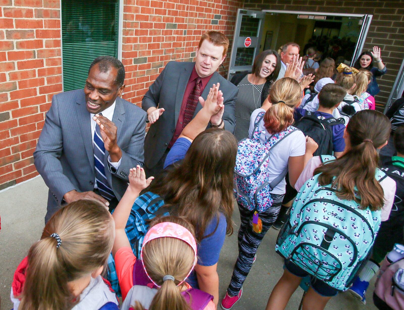 Lakota School board member Ray Murray and Superintendent Matt Miller along with several other administrators, welcomed students as they arrive at VanGorden Elementary, during their fanfare event, Wednesday, Aug. 30. GREG LYNCH / STAFF