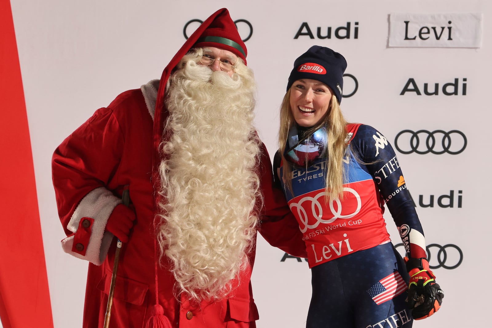 The winner United States' Mikaela Shiffrin celebrates on podium with Santa, after an alpine ski, women's World Cup slalom, in Levi, Finland, Saturday, Nov. 16, 2024. (AP Photo/Marco Trovati)