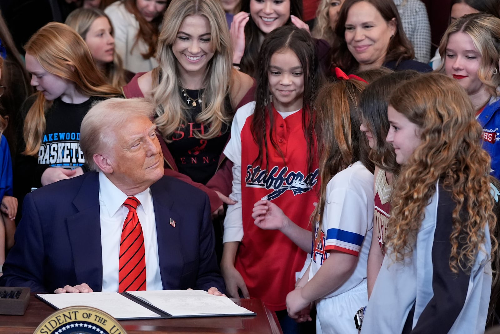 President Donald Trump signs an executive order barring transgender female athletes from competing in women's or girls' sporting events, in the East Room of the White House, Wednesday, Feb. 5, 2025, in Washington. (AP Photo/Alex Brandon)