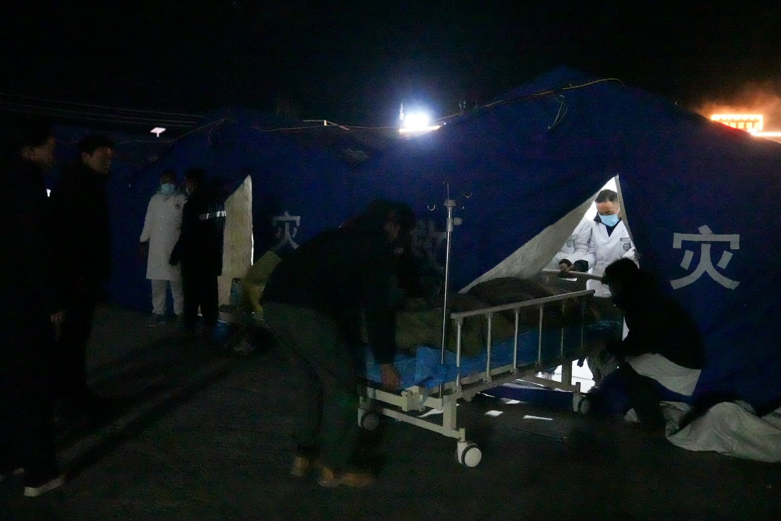 In this photo released by Xinhua News Agency, medical workers treat injured people at the temporary tents set up at the People's Hospital in the aftermath of an earthquake in Dingri County in Xigaze, southwest China's Xizang Autonomous Region on Tuesday, Jan. 7, 2025. (Ding Ting/Xinhua via AP)