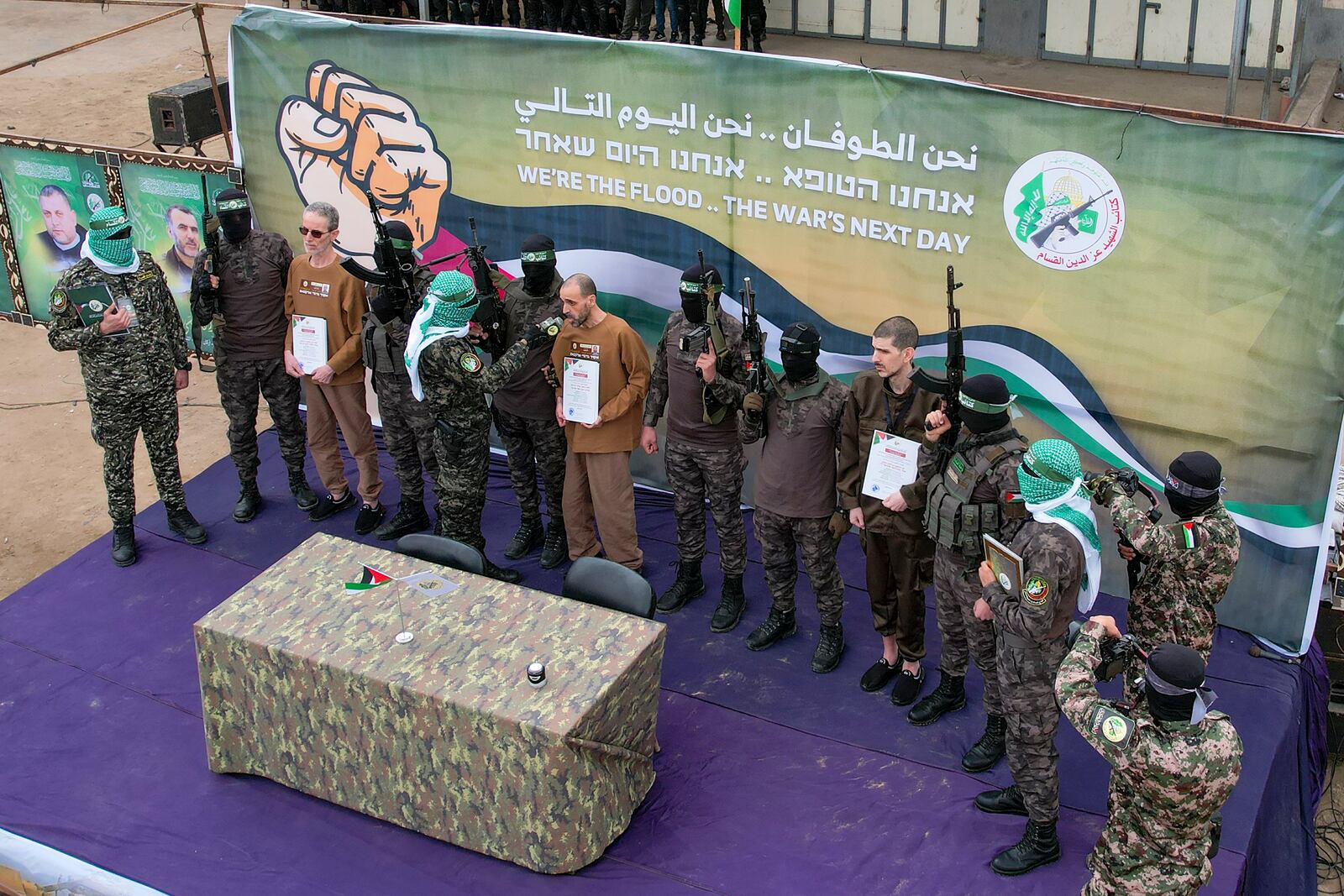 Israeli captives, Ohad Ben Ami, left and Eli Sharabi, right, who have been held hostage by Hamas in Gaza since October 7, 2023, are escorted and questioned by Hamas fighters before being handed over to the Red Cross in Deir al-Balah, central Gaza Strip, Saturday Feb. 8, 2025. (AP Photo/Mohammad Abu Samra)