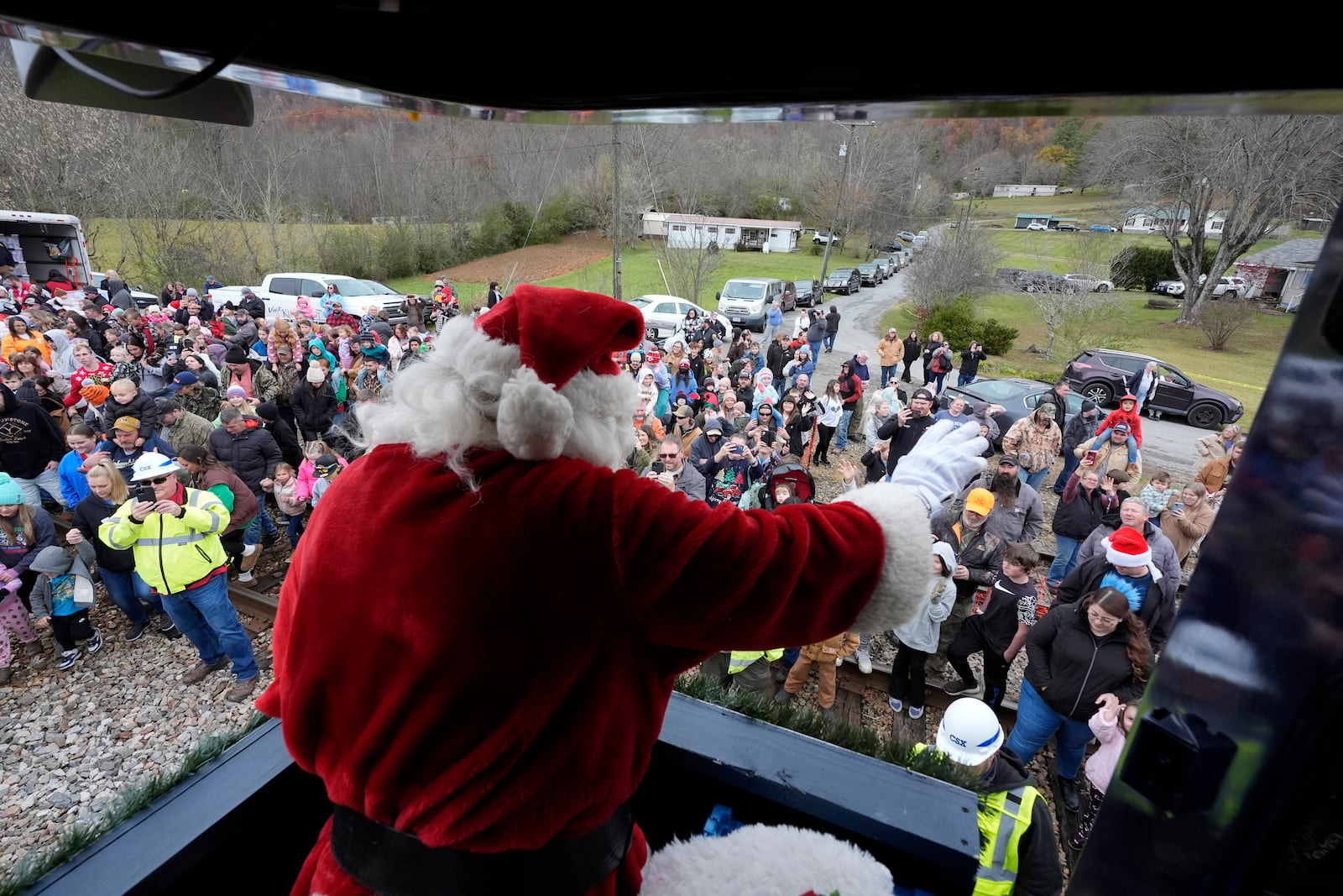 Santa Claus waves to people during the 82nd run of the CSX Santa Train, Saturday, Nov. 23, 2024, in Kermit, Va. The train brings presents to small towns along a 110-mile portion of the railroad line in rural Appalachian Tennessee, Kentucky and Virginia. (AP Photo/George Walker IV)