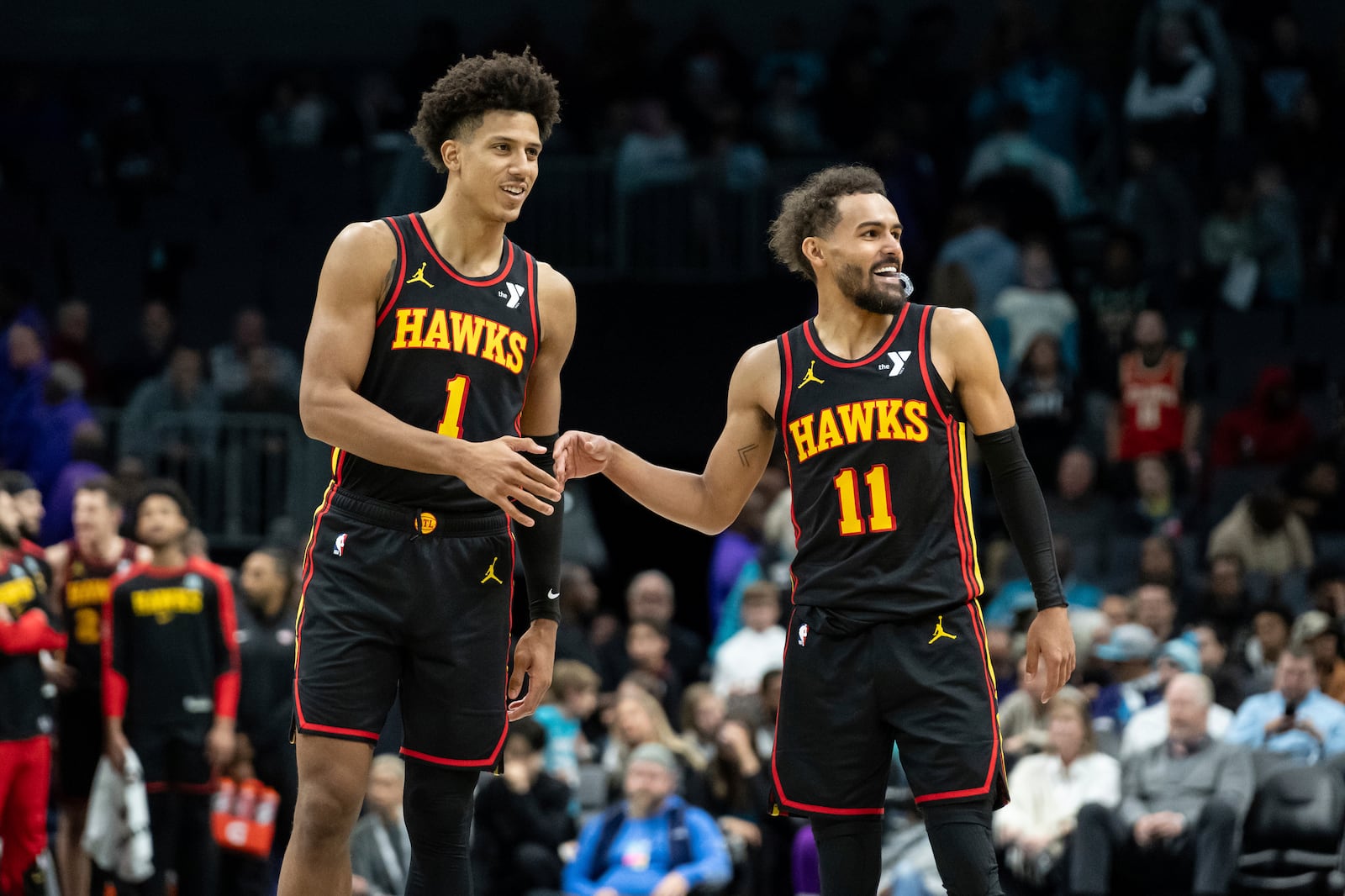 Atlanta Hawks forward Jalen Johnson (1) and guard Trae Young (11) high-five during the second half of an NBA basketball game against the Charlotte Hornets, Saturday, Nov. 30, 2024, in Charlotte, N.C. (AP Photo/Matt Kelley)