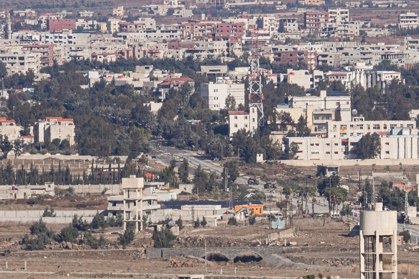 Israeli tanks park on the buffer zone after the Quneitra crossing, between Israel and Syria, are viewed from the Israeli-controlled Golan Heights, Friday, Dec. 13, 2024. (AP Photo/Matias Delacroix)