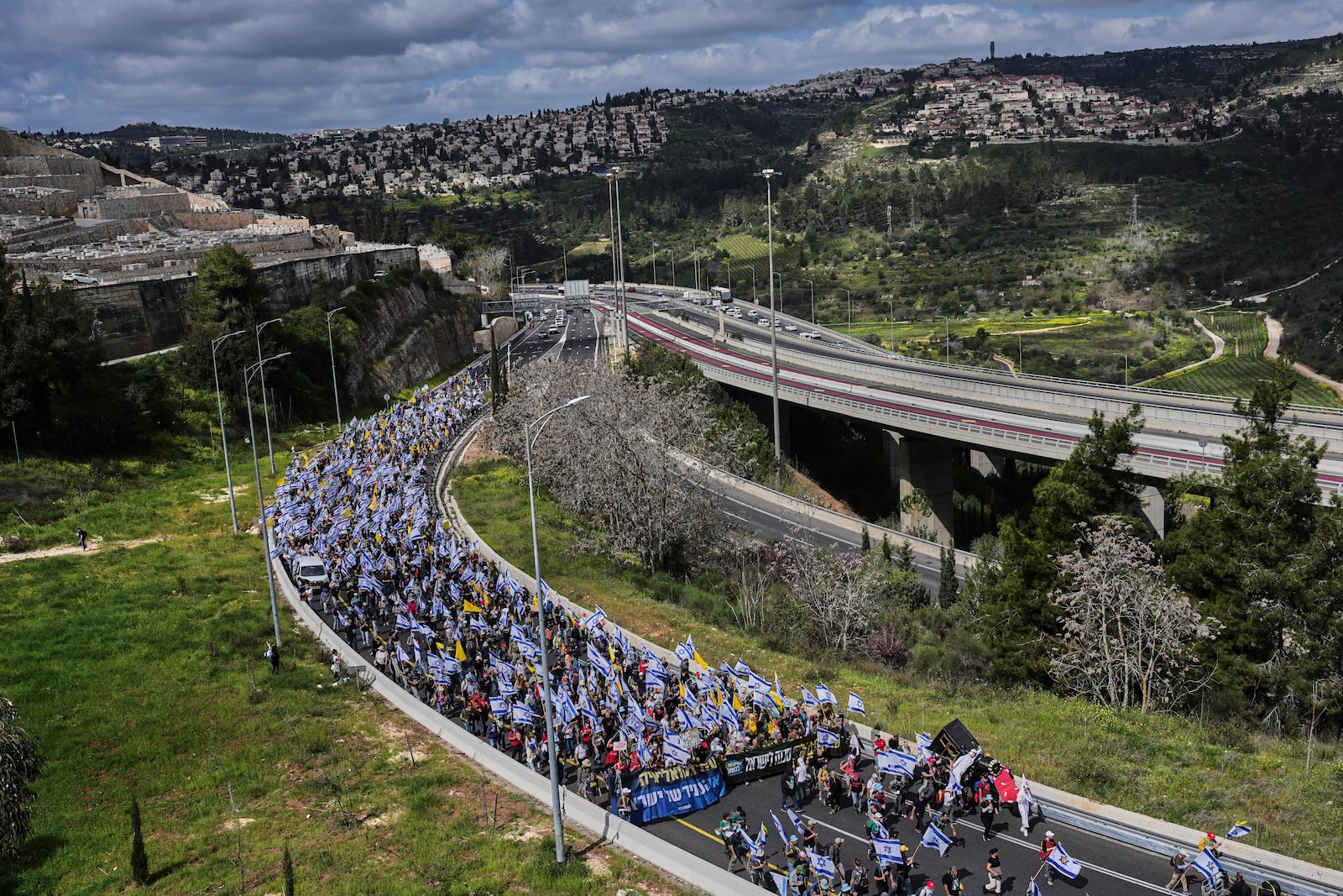 Israelis march on a highway toward Jerusalem to protest Prime Minister Benjamin Netanyahu's plans to dismiss the head of the Shin Bet internal security service, on Wednesday, March 19, 2025. (AP Photo/Ohad Zwigenberg)