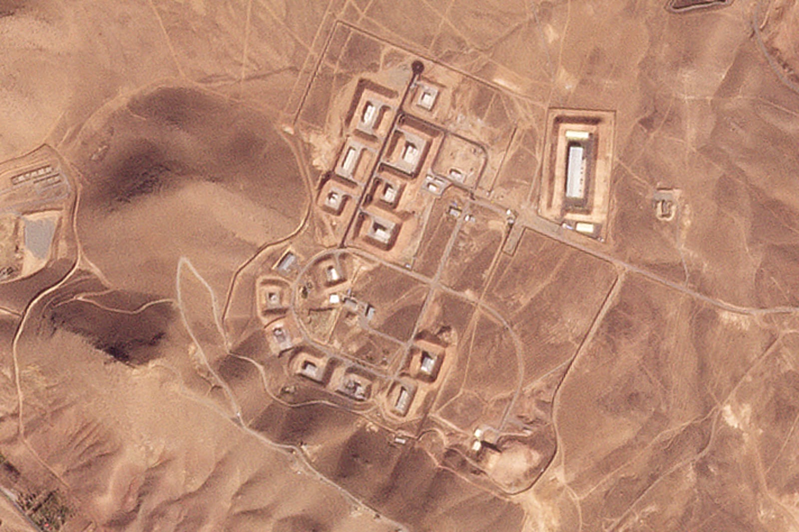 This satellite photo from Planet Labs PBC shows damaged buildings at Iran's Khojir military base outside of Tehran, Iran, Saturday, Oct. 26, 2024. An Israeli attack on Iran damaged facilities at a secretive military base southeast of the Iranian capital that experts in the past have linked to Tehran's onetime nuclear weapons program and at another base tied to its ballistic missile program, satellite photos analyzed Sunday by The Associated Press show. The damaged structures are in the bottom center of the image. (Planet Labs PBC via AP)