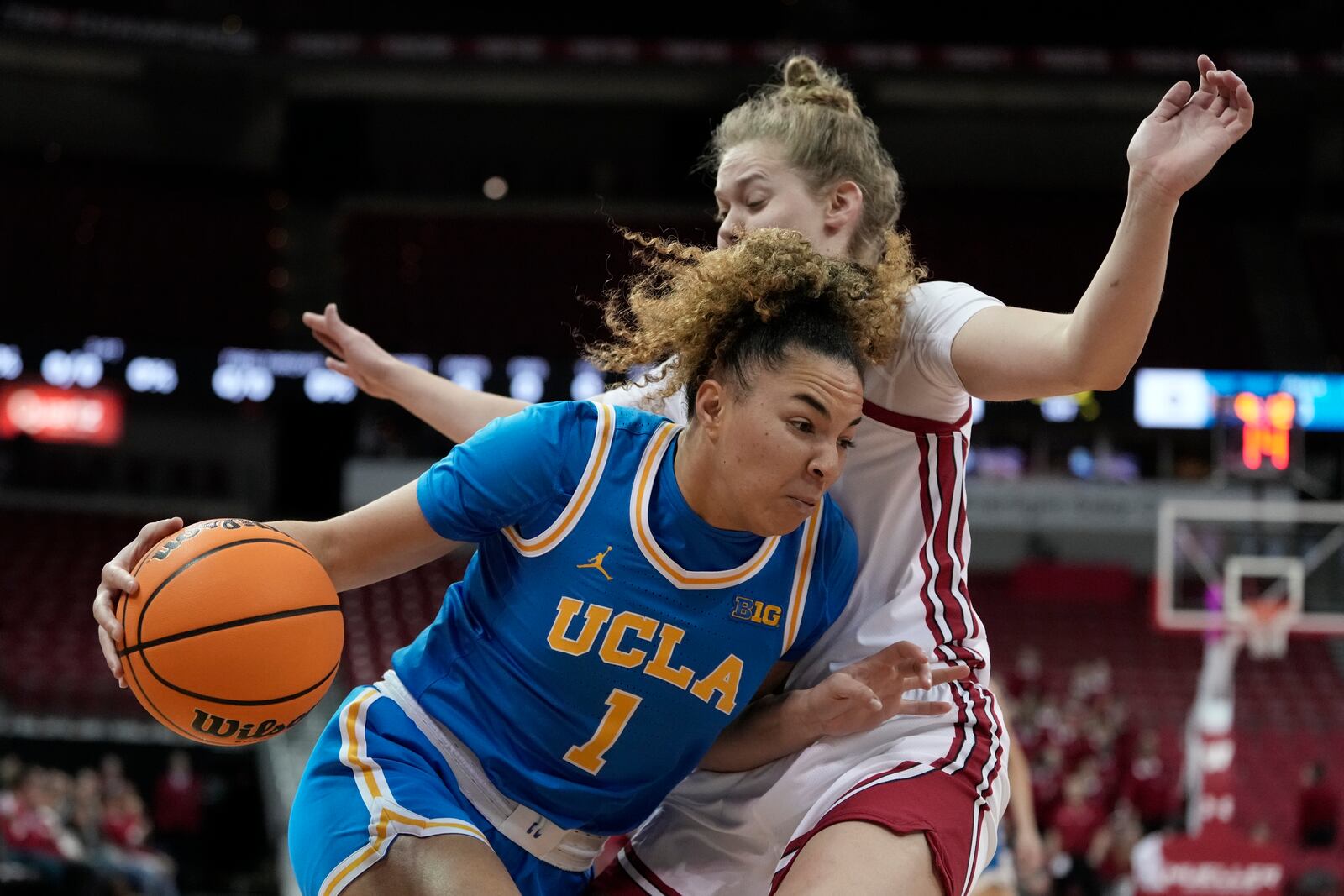 UCLA's Kiki Rice tries to get past Wisconsin's Natalie Leuzinger during the first half of an NCAA college basketball game Wednesday, Feb. 26, 2025, in Madison, Wis. (AP Photo/Morry Gash)