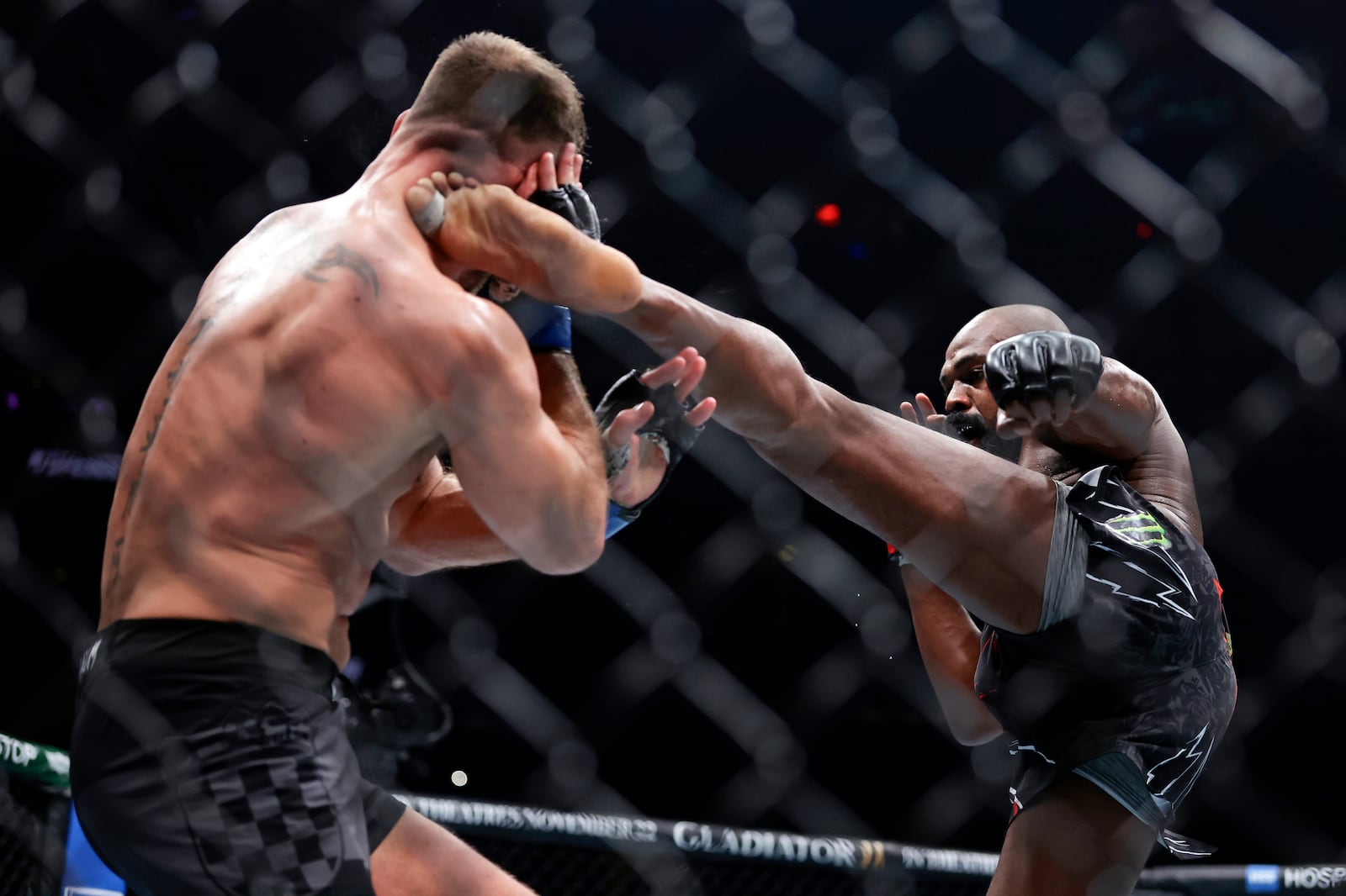 Jon Jones, right, kicks Stipe Miocic in a UFC 309 mixed martial arts heavyweight title bout, early on Sunday, Nov. 17, 2024, in New York. (AP Photo/Adam Hunger)