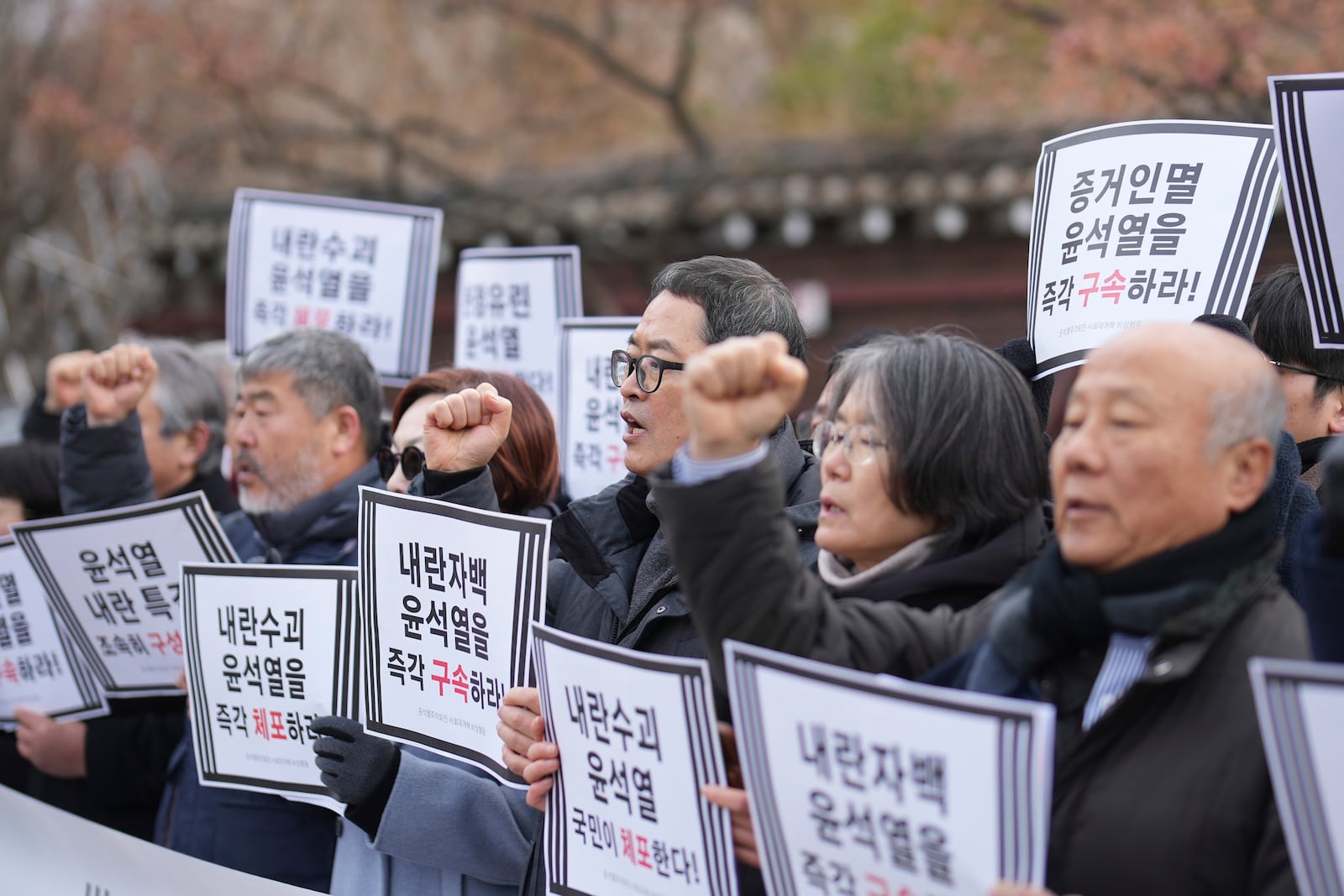 Members of civic groups shout slogans during a news conference demanding the arrest of President Yoon Suk Yeol near the presidential residence in Seoul, South Korea, Tuesday, Dec. 17, 2024. The letters read "Immediately arrest Yoon Suk Yeol." (AP Photo/Lee Jin-man)