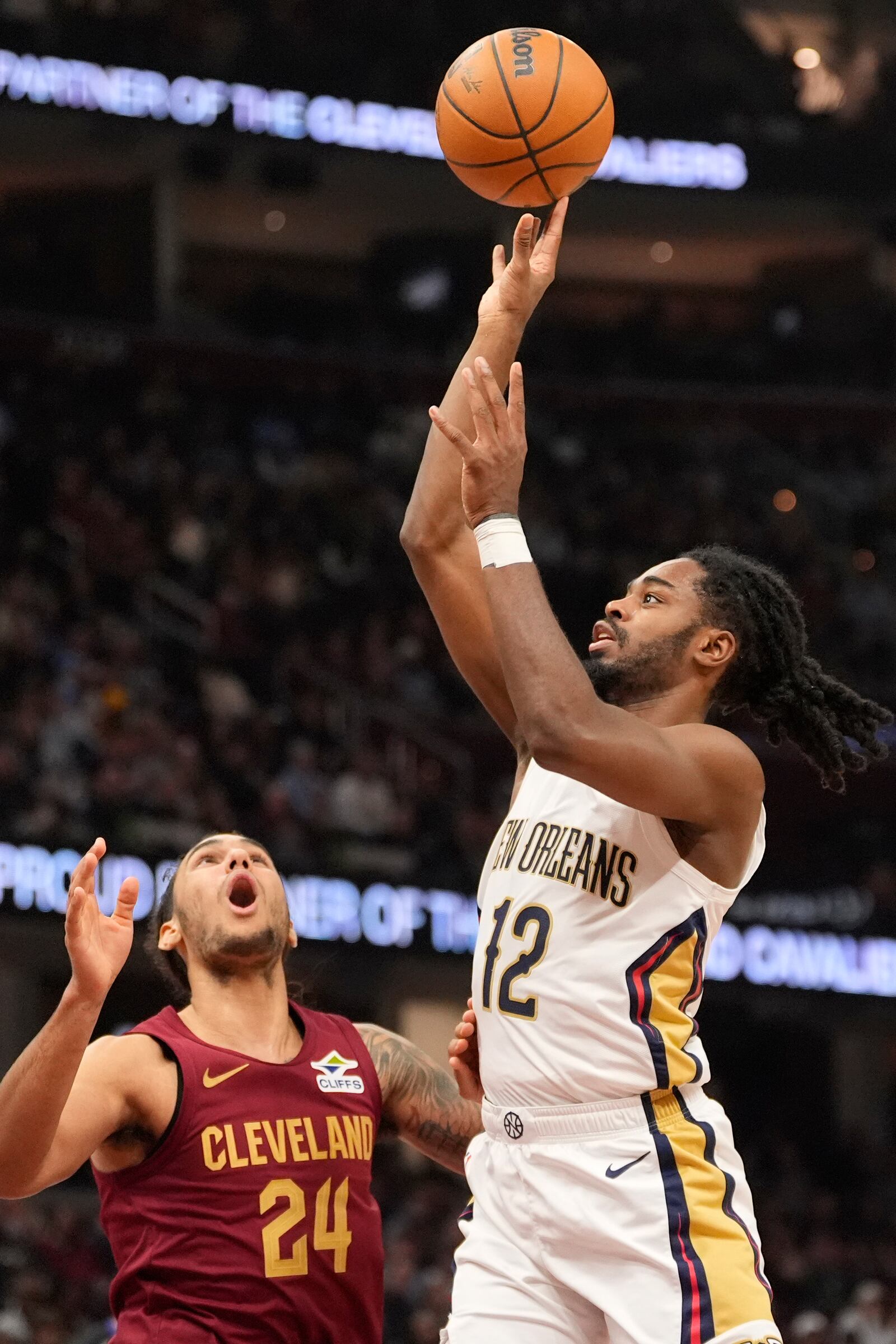 New Orleans Pelicans guard Antonio Reeves (12) shoots in front of Cleveland Cavaliers forward Jaylon Tyson (24) in the first half of an NBA basketball game, Wednesday, Nov. 20, 2024, in Cleveland. (AP Photo/Sue Ogrocki)