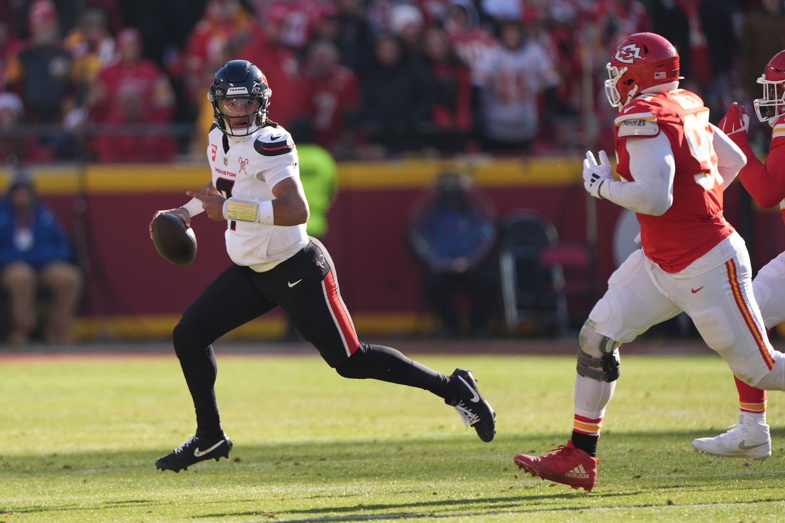 Houston Texans quarterback C.J. Stroud, left, scrambles as Kansas City Chiefs defensive tackle Chris Jones, right, defends during the first half of an NFL football game Saturday, Dec. 21, 2024, in Kansas City, Mo. (AP Photo/Charlie Riedel)