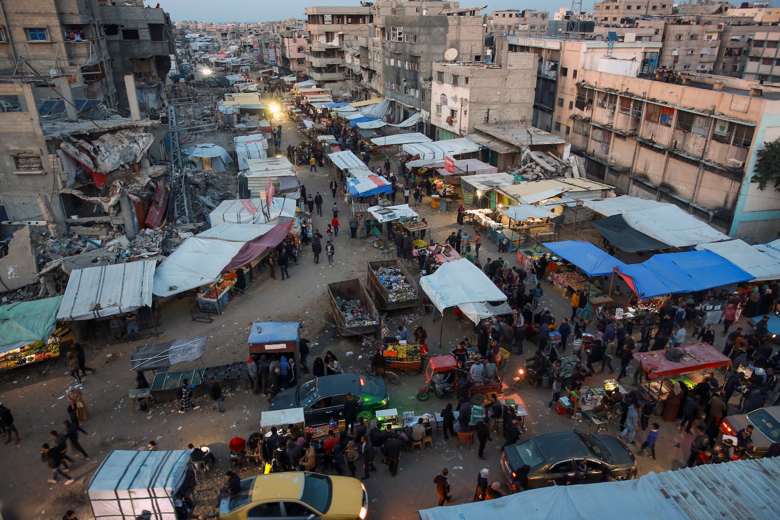 Palestinians walk along a street market in Khan Younis, central Gaza Strip, Saturday Jan. 18, 2025.(AP Photo/(AP Photo/Jehad Alshrafi)