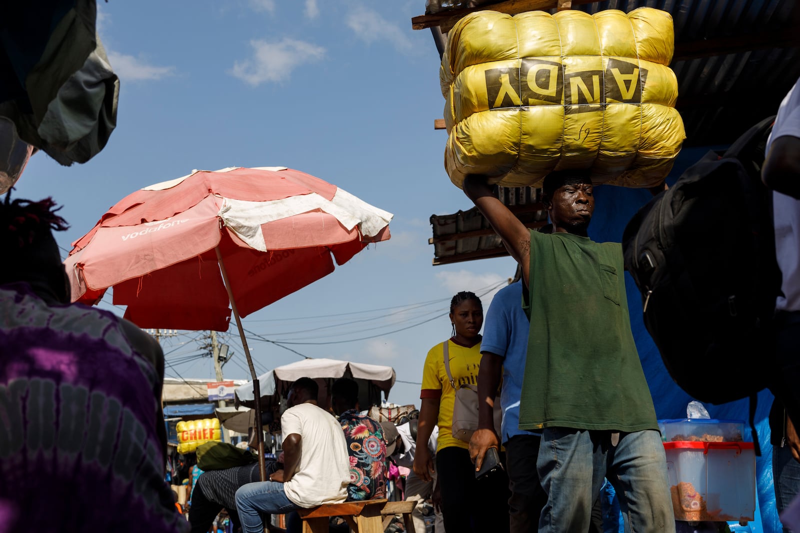 A head porter carries a bale of Second-hand clothes at Kantamanto market, one of the world's largest second-hand clothes markets in Accra, Ghana, Thursday, Oct. 31, 2024. (AP Photo/Misper Apawu)