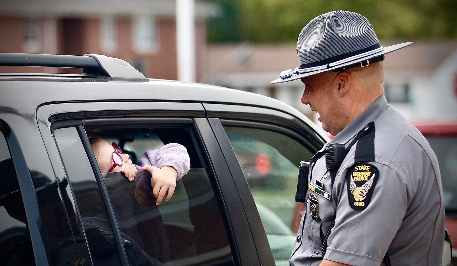 Five-year-old Eilyn Jenkins talks with Sgt. Scott Schweinfuth of the Ohio State Highway Patrol on Tuesday, Sept. 17, 2024 at Snowhill Elementary in Springfield. MARSHALL GORBY\STAFF