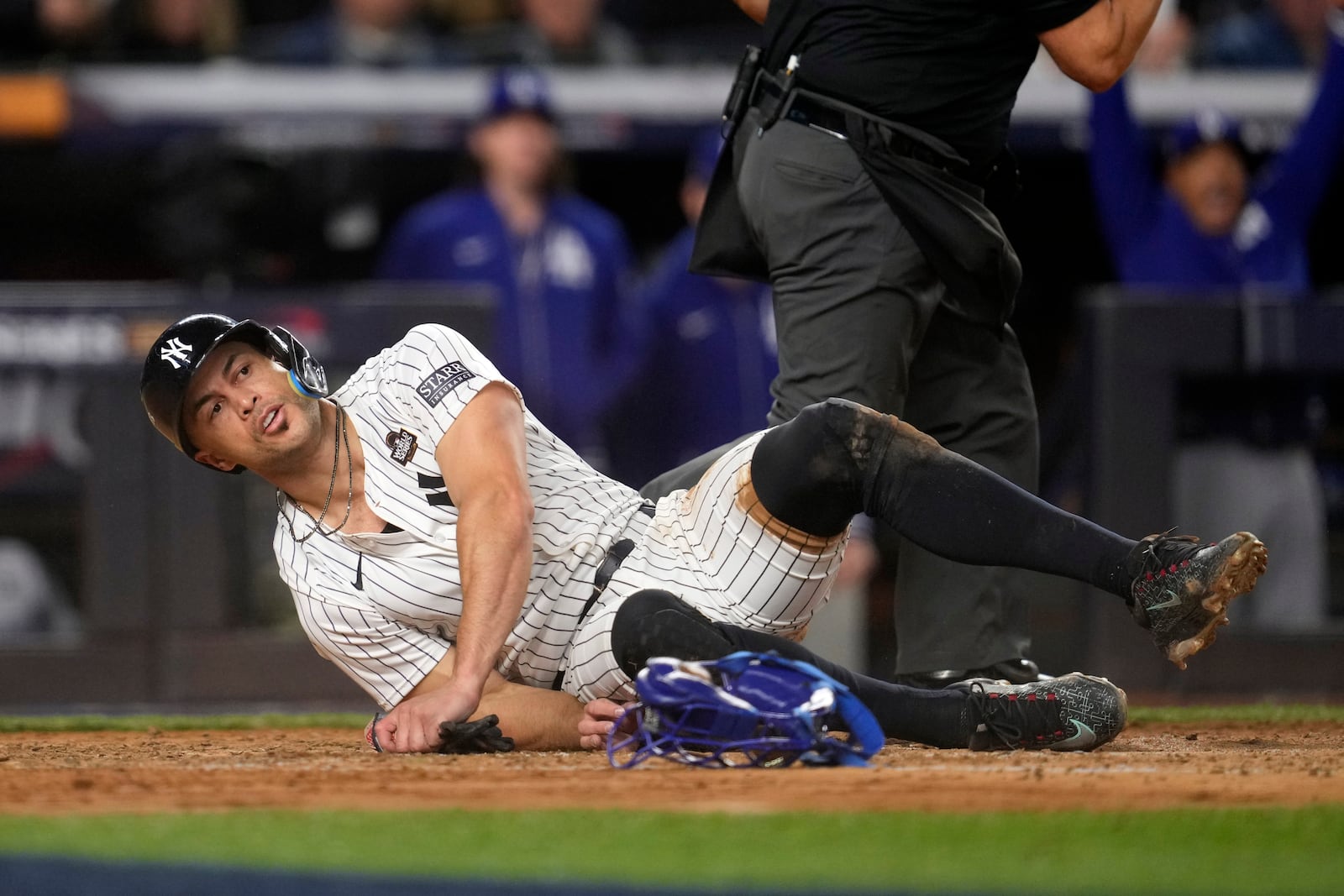 New York Yankees' Giancarlo Stanton lies on the ground after being tagged out while trying to score against the Los Angeles Dodgers during the fourth inning in Game 3 of the baseball World Series, Monday, Oct. 28, 2024, in New York. (AP Photo/Godofredo A. Vásquez)